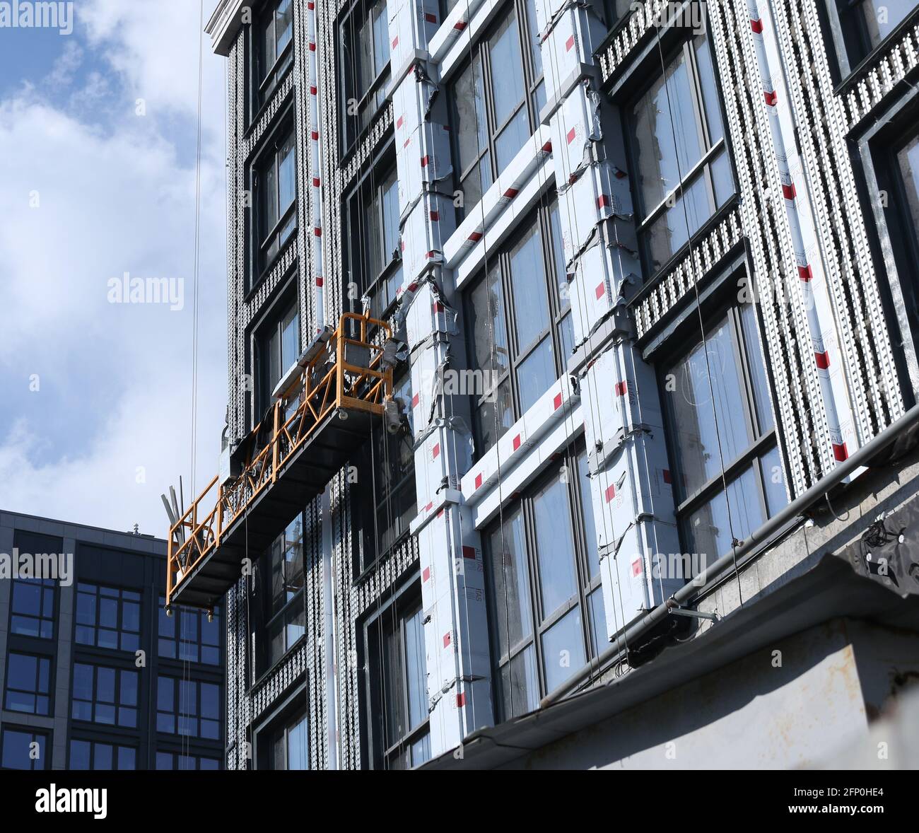 Construction d'un bâtiment de plusieurs étages. Travaux de finition d'extérieur en hauteur. Banque D'Images