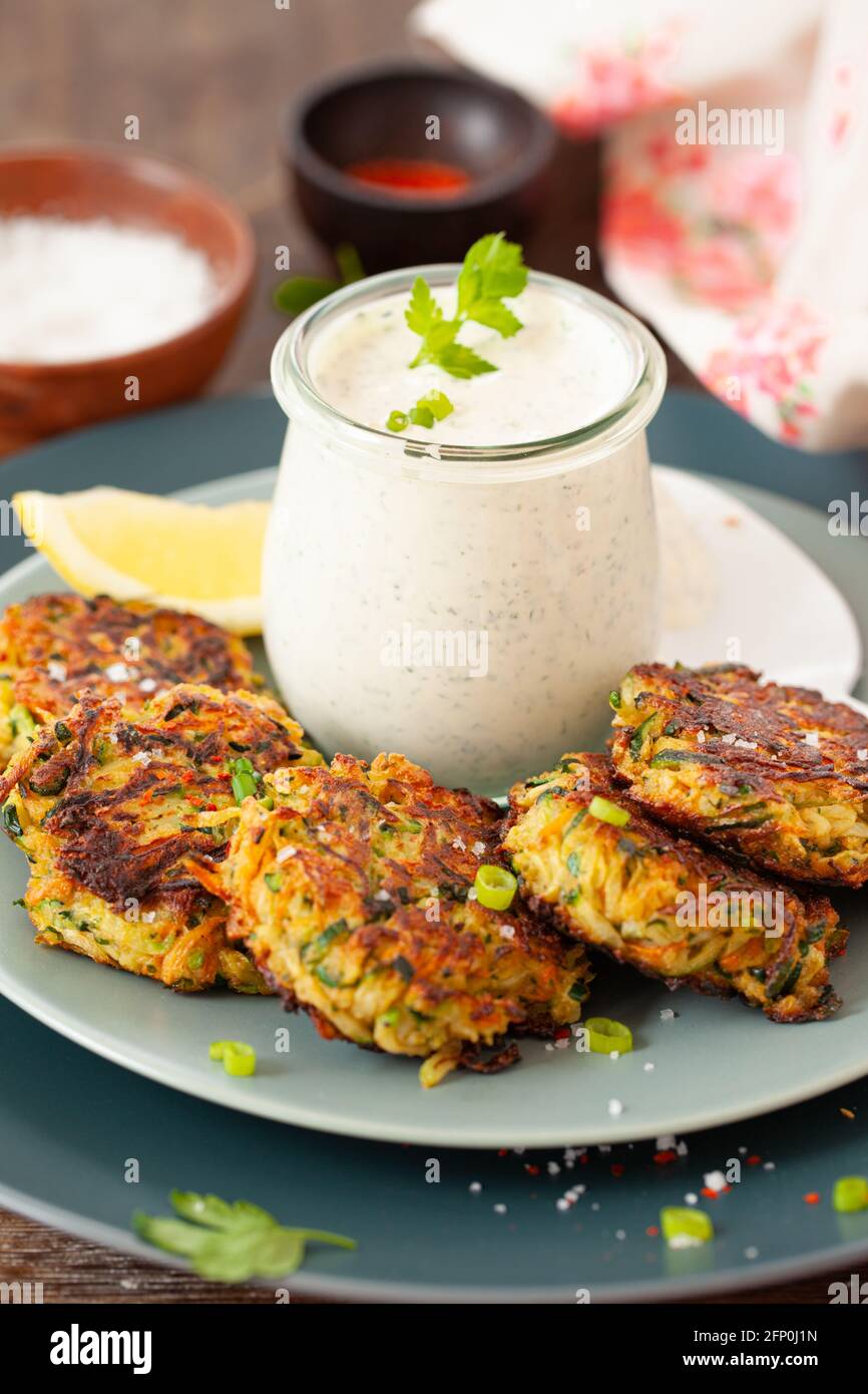 Beignets de légumes aux courgettes salés avec une sauce à la crème aigre Banque D'Images