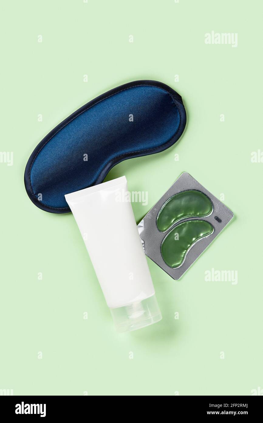 Masque de sommeil, pince et timbres oculaires sur le fond vert. Soins du visage concept de soins de beauté Banque D'Images
