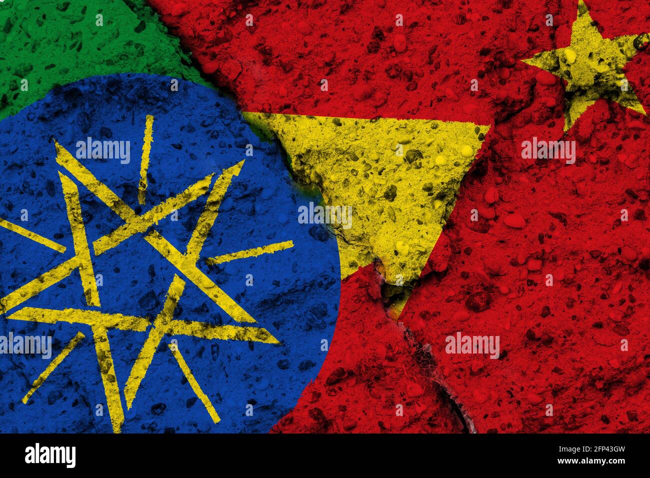 Concept d'un conflit dans la région éthiopienne du Tigré avec des drapeaux peints sur un mur rugueux avec une fissure Banque D'Images