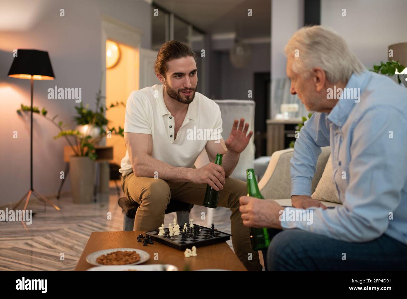 Petit-fils parlant avec le grand-père après la partie d'échecs Banque D'Images