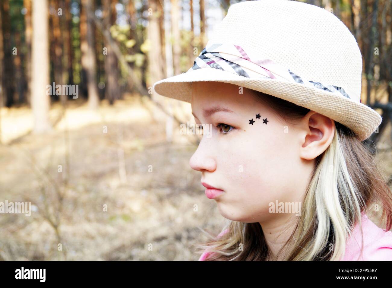 Une adolescente dans un chapeau marche dans un conifères forêt Banque D'Images