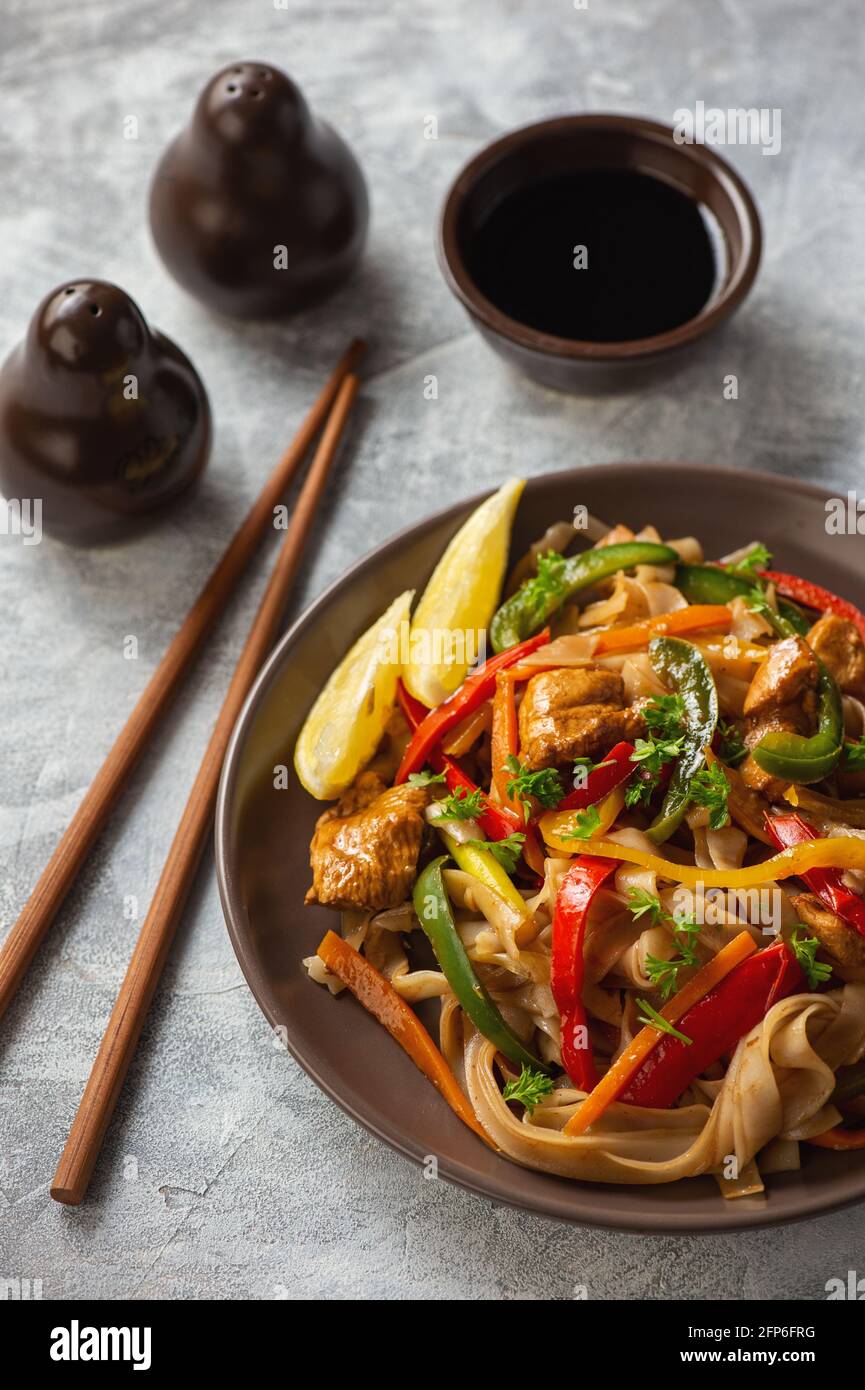 Nouilles de riz au poulet, soja et légumes, cuisine asiatique. Banque D'Images