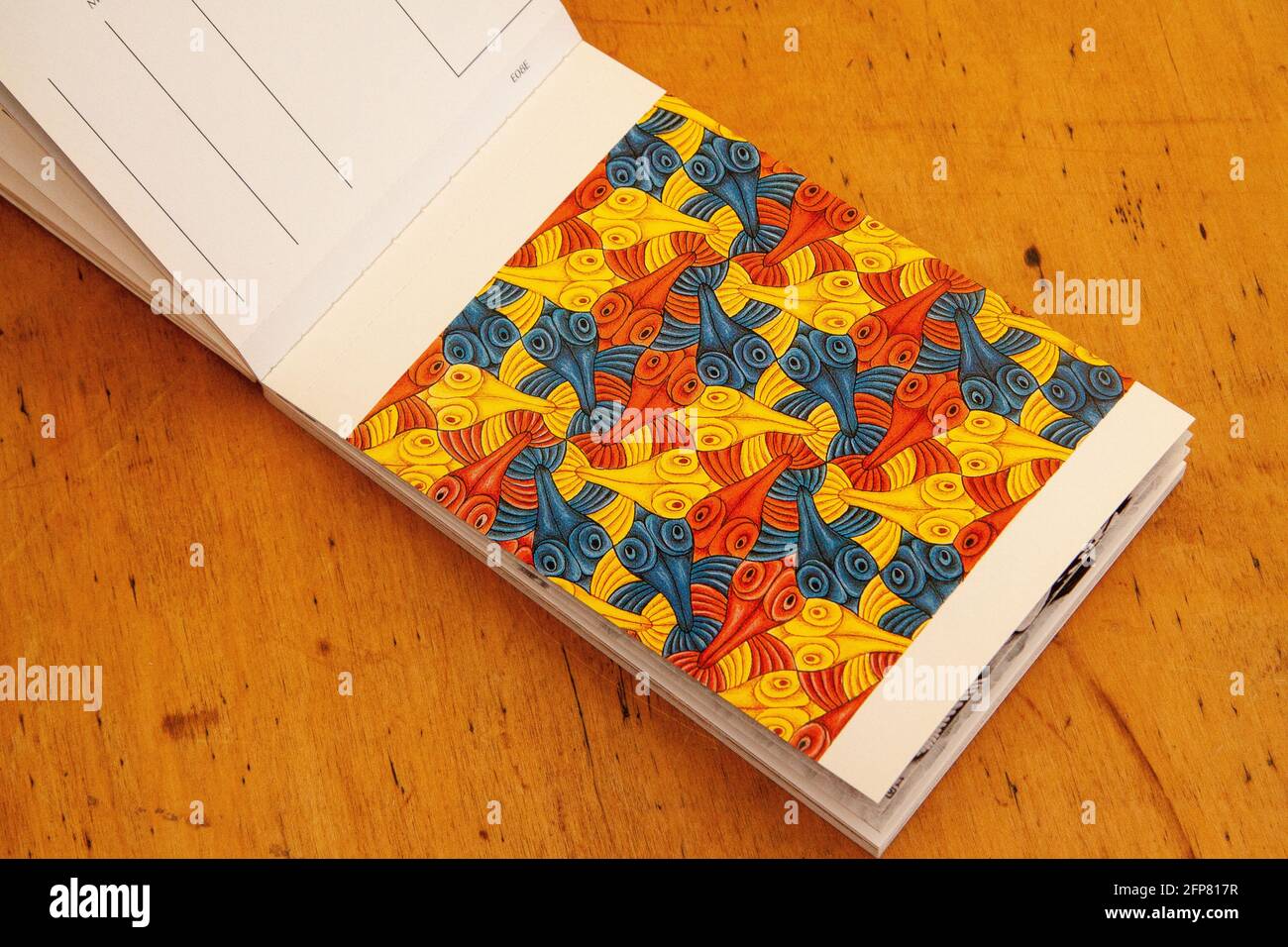 Arrachez une carte postale dans un livre des imaginations mathématiques de MC Escher. Une collection d'œuvres souvent déroutantes de l'artiste graphique néerlandais. Banque D'Images