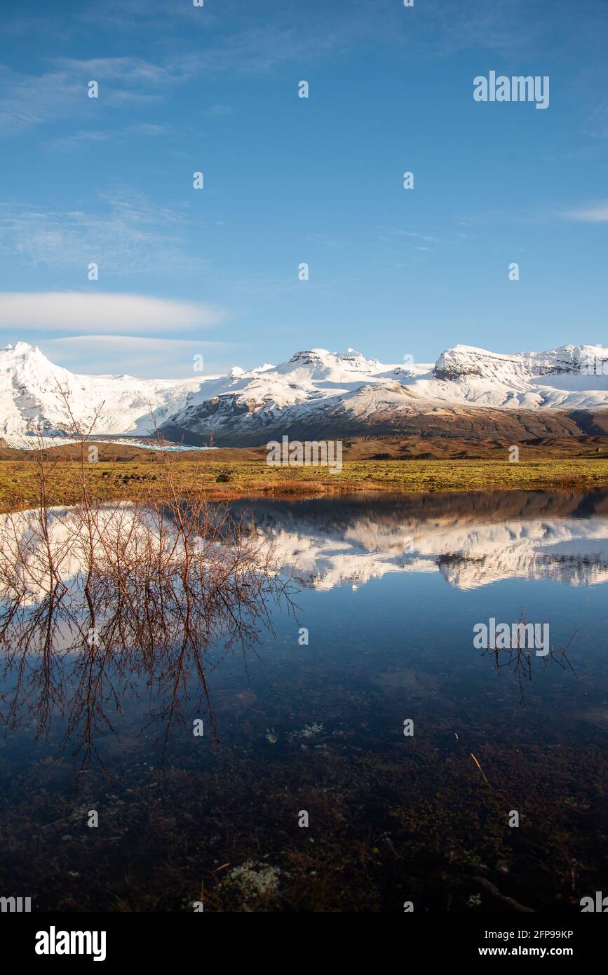 Chaîne de montagnes islandaise avec de belles montagnes enneigées se  reflétant dans l'eau fixe Photo Stock - Alamy