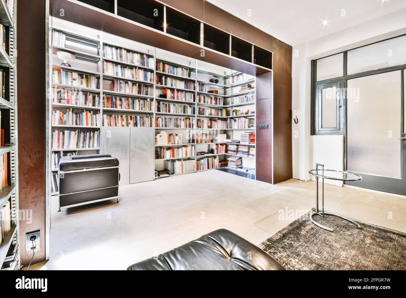 Décoration intérieure contemporaine, bibliothèque de luxe avec étagères  forme de niche et chaise en cuir dans un appartement moderne Photo Stock -  Alamy