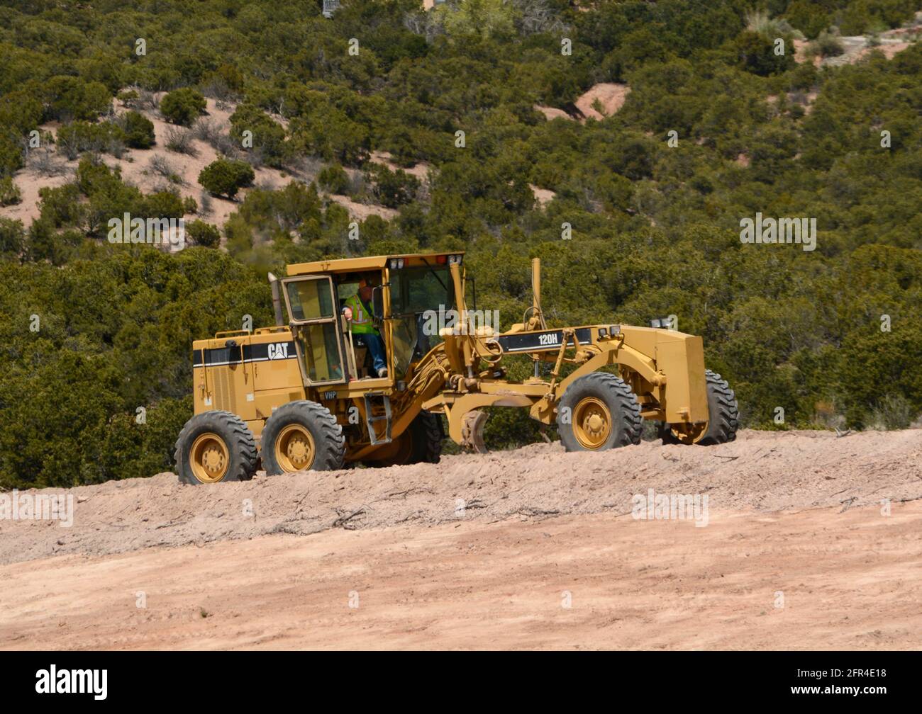 Un conducteur d'équipement lourd utilise une niveleuse 120H Caterpillar pour déplacer la saleté sur un chantier d'amélioration de la route au Nouveau-Mexique. Banque D'Images