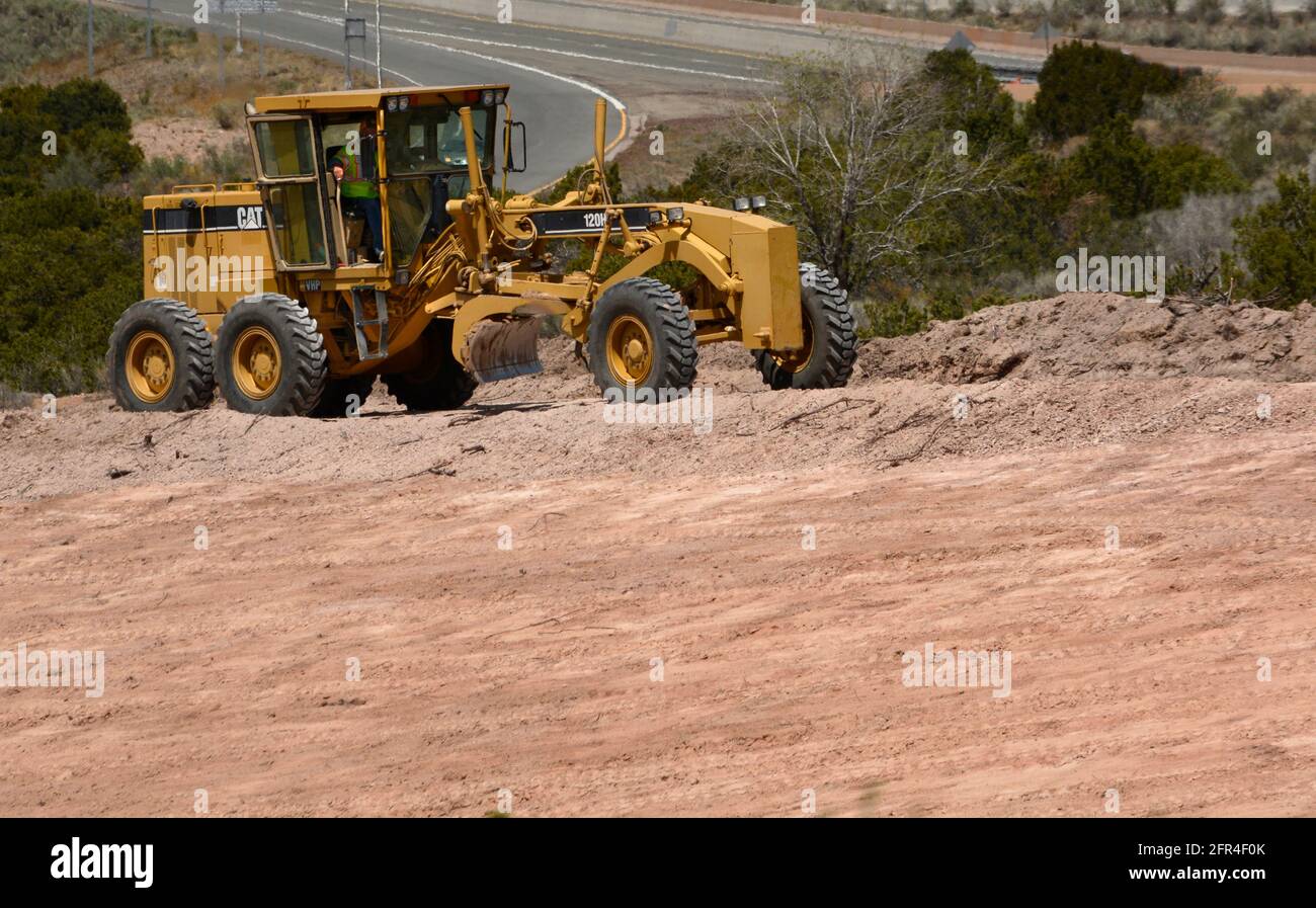 Un conducteur d'équipement lourd utilise une niveleuse 120H Caterpillar pour déplacer la saleté sur un chantier d'amélioration de la route au Nouveau-Mexique. Banque D'Images