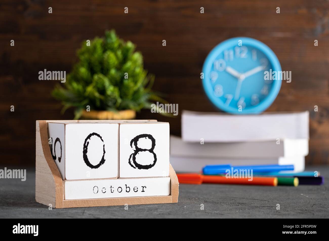 Le 08 octobre. Octobre 08 calendrier cube en bois avec objets flous sur fond. Banque D'Images