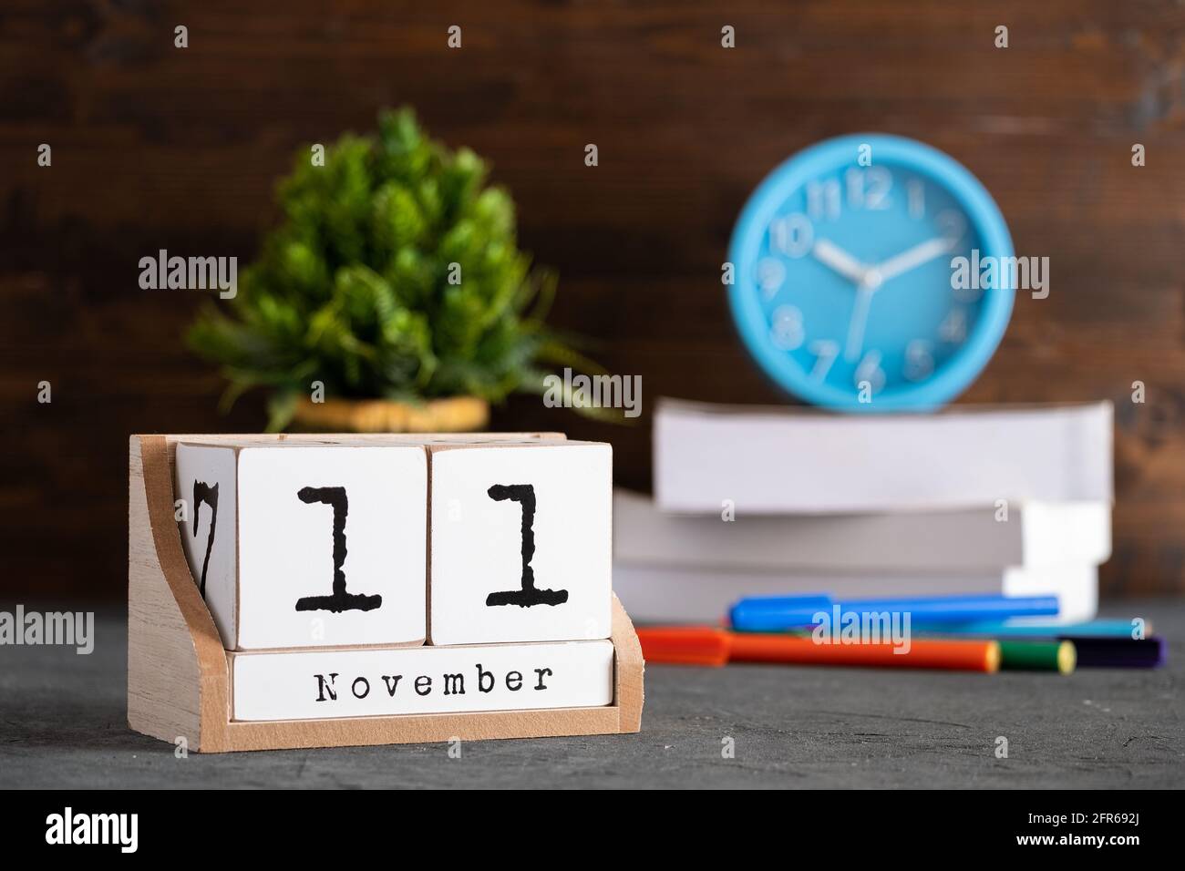 11 novembre. Calendrier cubique en bois de novembre 11 avec objets flous sur fond. Banque D'Images
