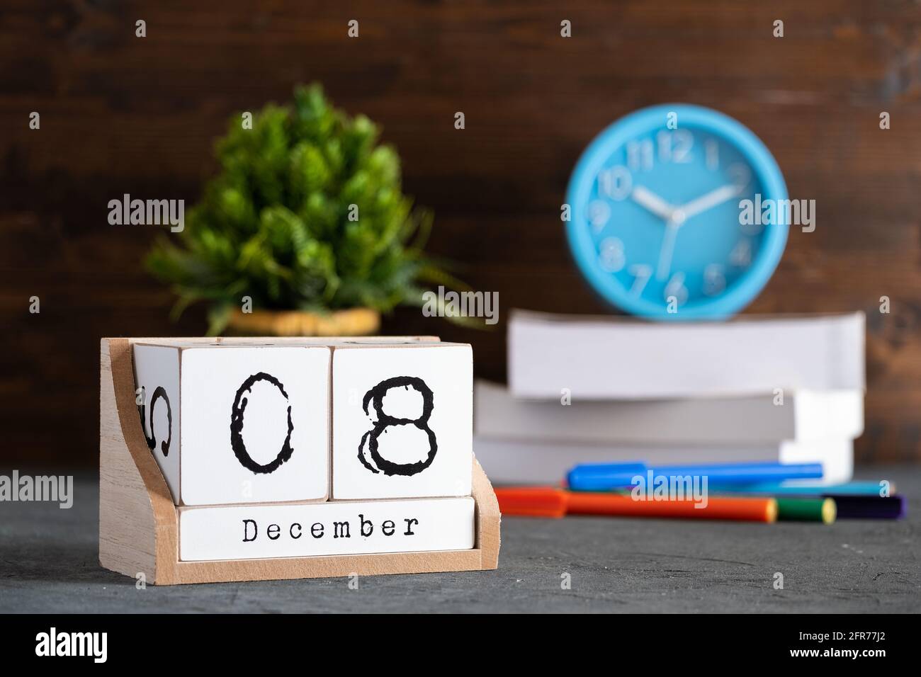 Le 08 décembre. Décembre 08 calendrier cube en bois avec des objets flous sur fond. Banque D'Images