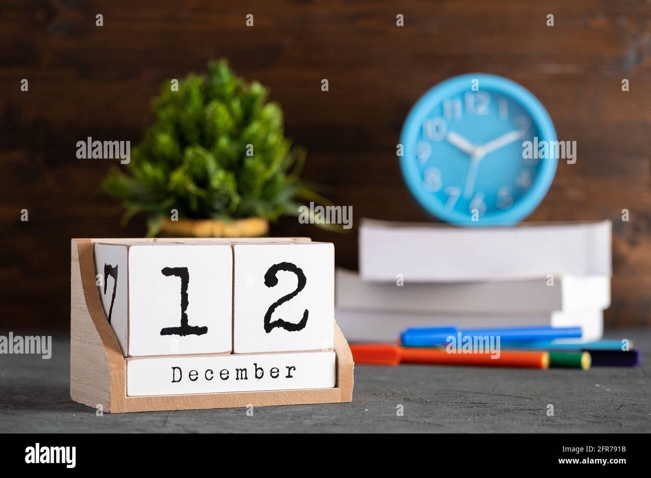 12 décembre. Décembre 12 calendrier cube en bois avec des objets flous sur fond. Banque D'Images