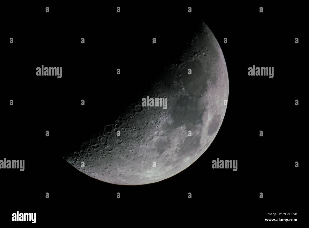 Vue sur une lune de gibbous épiée juste à côté d'une demi-lune. Banque D'Images