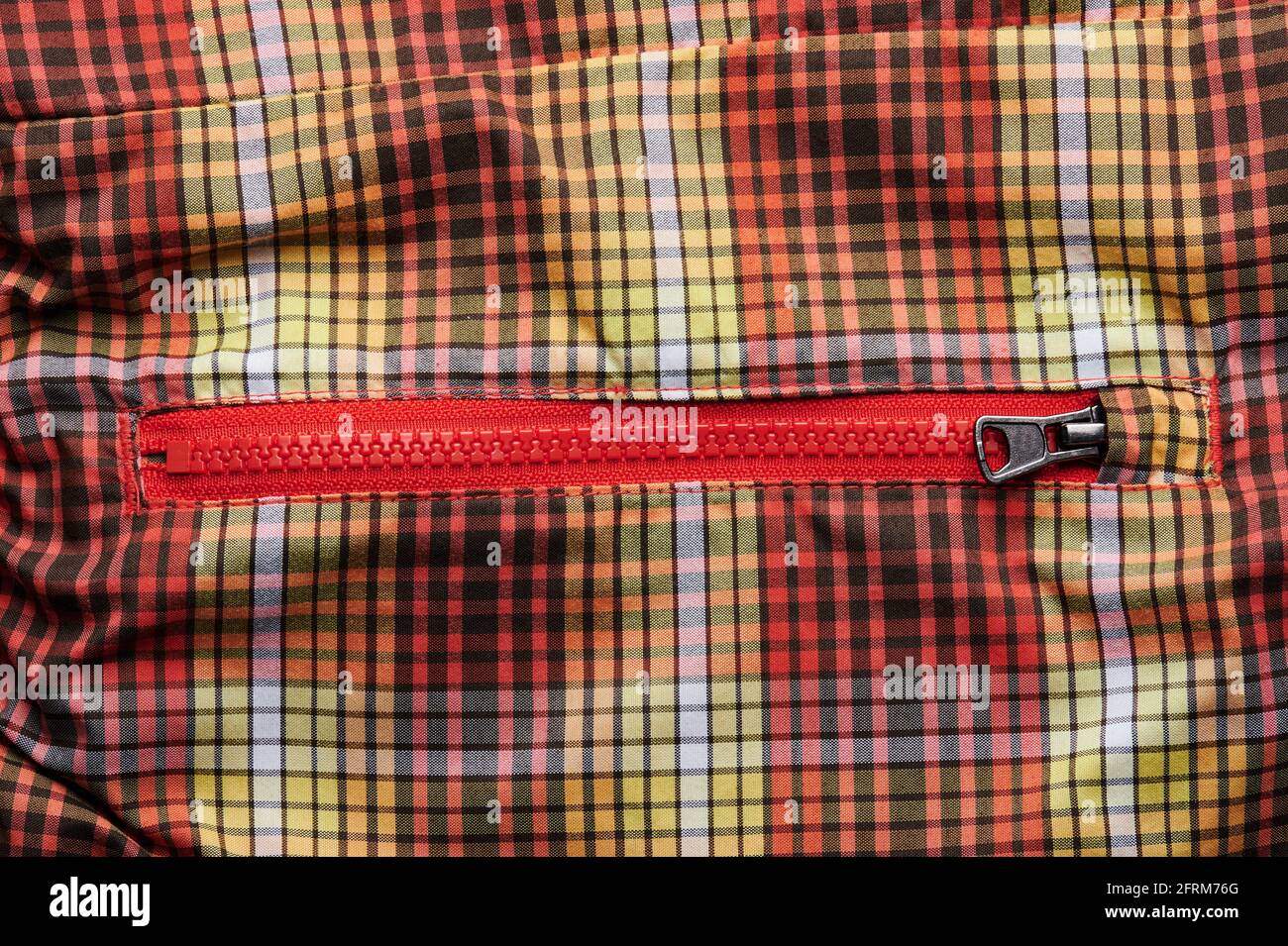 Poche fermée avec fermeture éclair sur fond textile rouge orange Banque D'Images