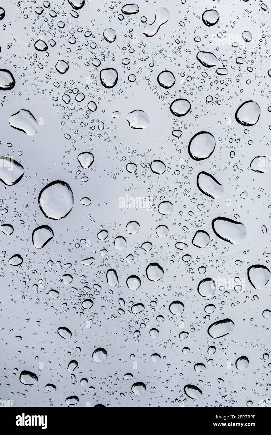 Gouttes de pluie sur une fenêtre pendant une tempête de pluie printanière Banque D'Images