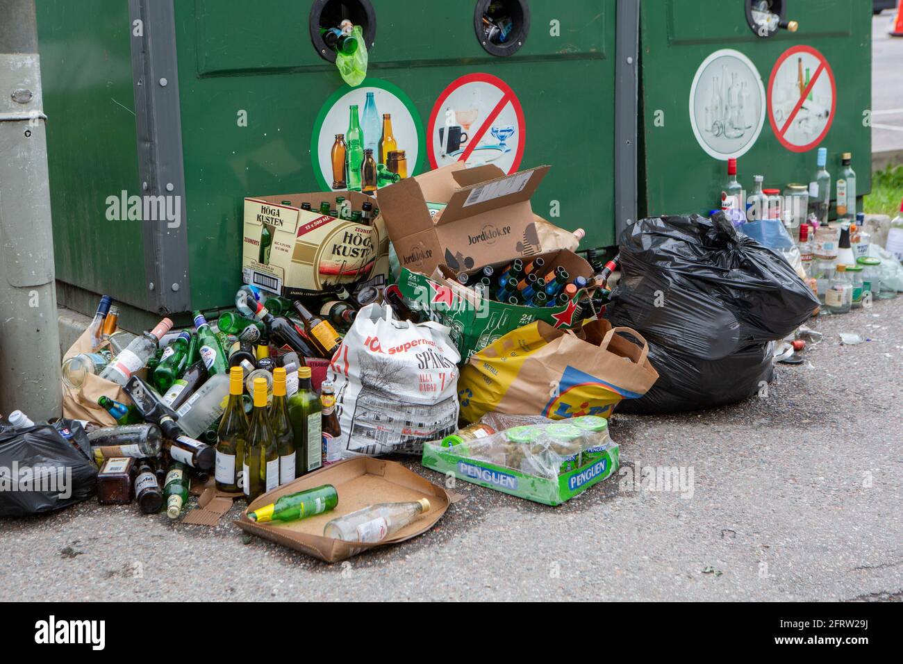 Les gens jettent des déchets à l'extérieur des conteneurs. Banque D'Images