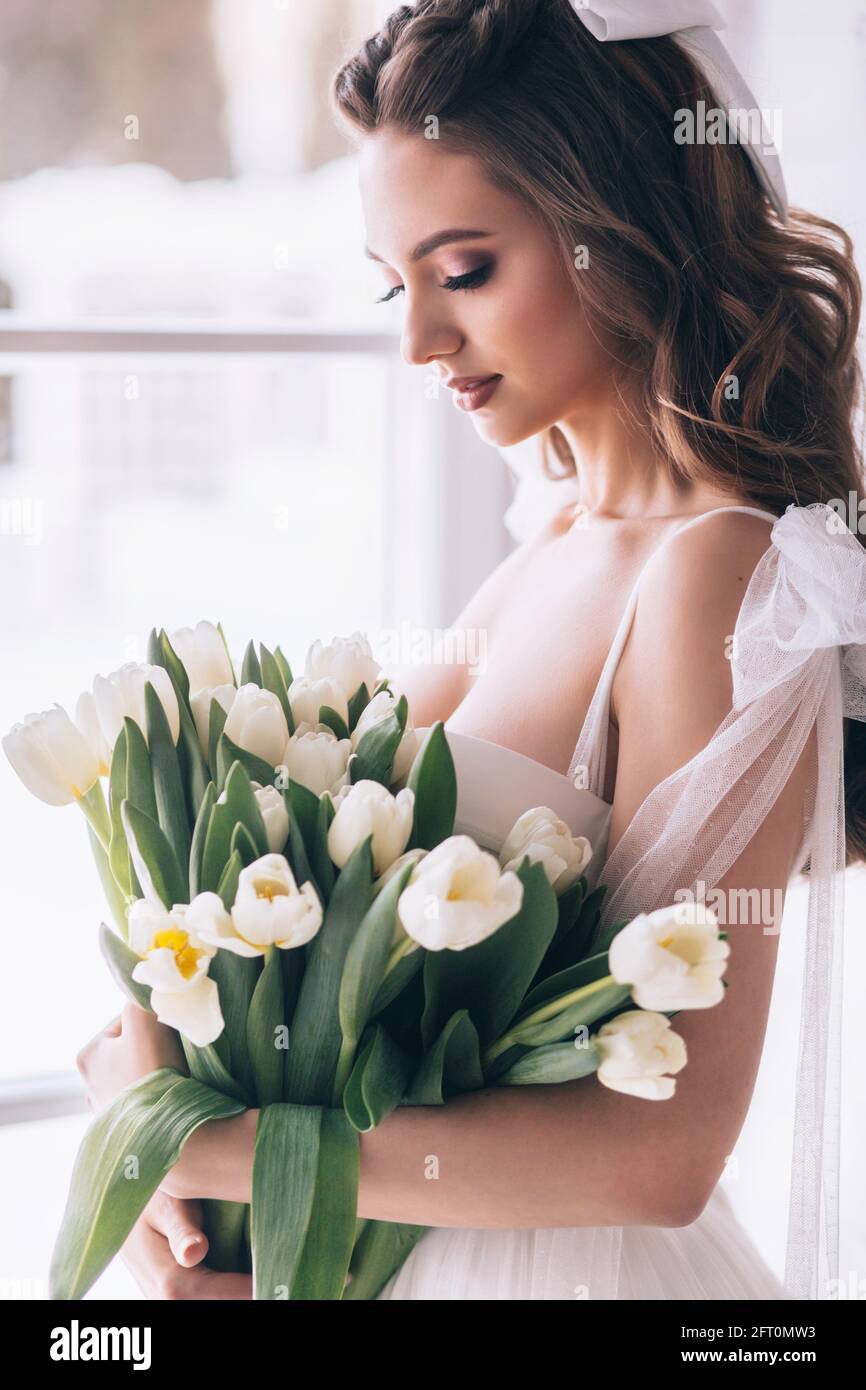 Bouquet de mariage de tulipes blanches entre les mains d'une belle mariée. Mise au point sélective Banque D'Images