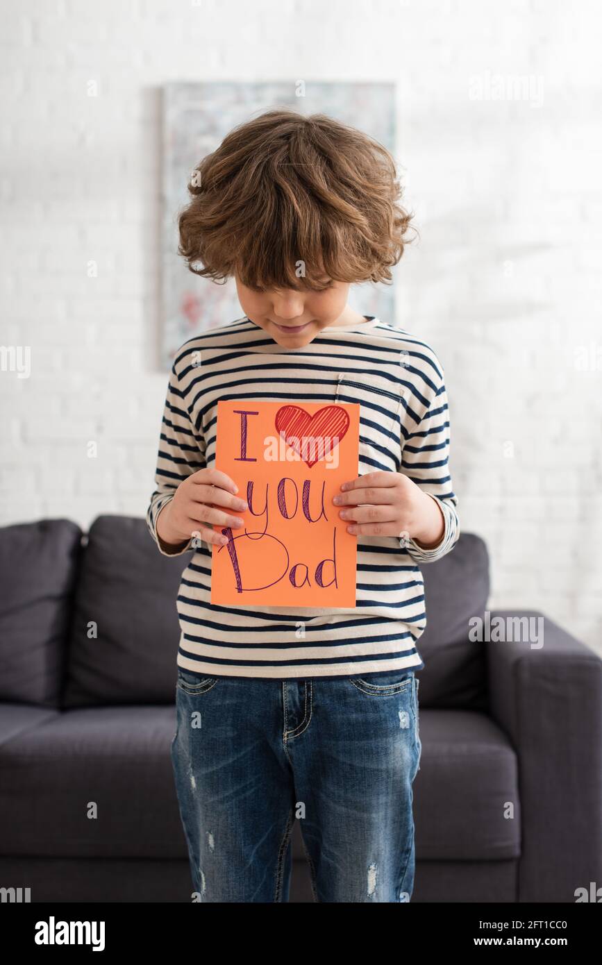 Garçon regardant la carte-cadeau avec moi je t'aime papa lettrage à la maison Banque D'Images