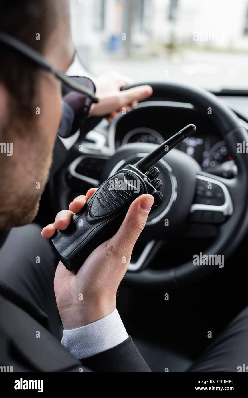 protège-corps flou dans les lunettes de soleil avec talkie-walkie en  voiture Photo Stock - Alamy