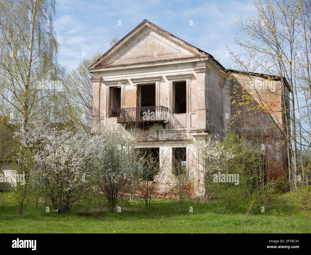 Vereskovo, Bélarus - 9 mai 2021 : palais en ruines et abandonné entouré d'arbres en fleurs Banque D'Images