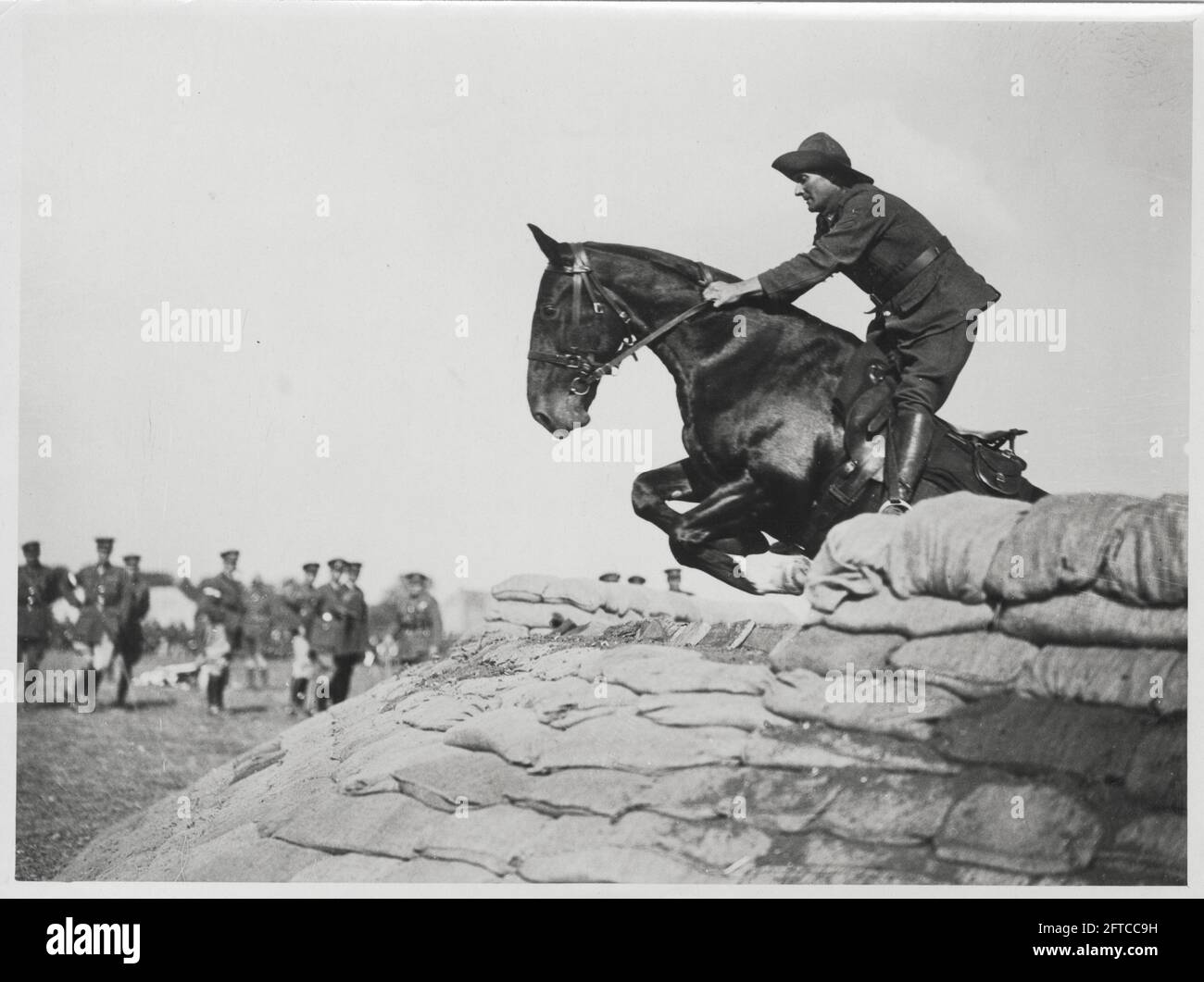 World War One, WWI, Western Front - UN cheval saute des sacs de sable à la New Zealand Division Horse show près du Western Front comme NCO (non-commissionnaires) et leurs hommes regardent sur Banque D'Images
