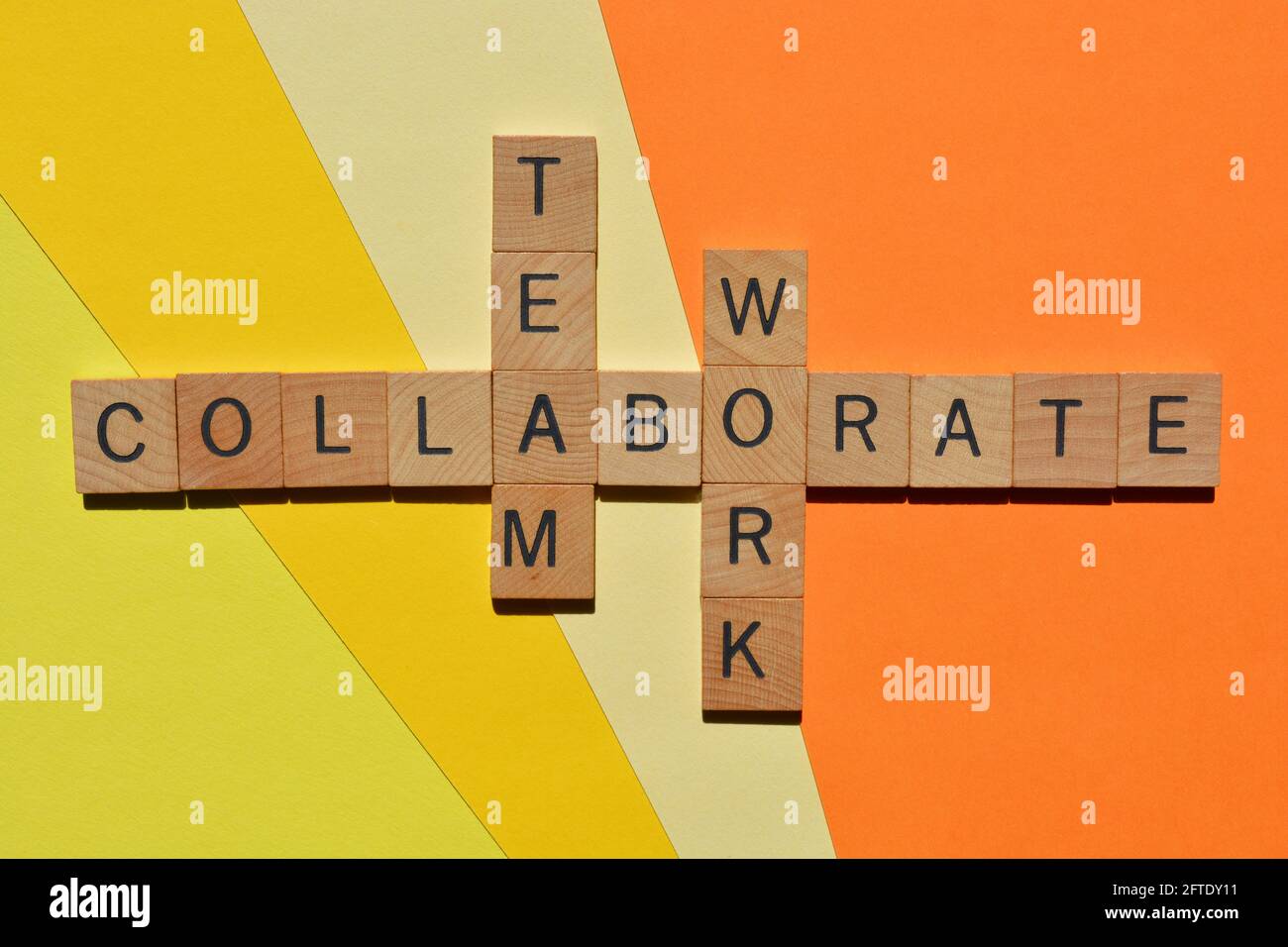 Collaborer, équipe, travail, mots en lettres de l'alphabet en bois en forme de mots croisés isolés sur fond coloré Banque D'Images