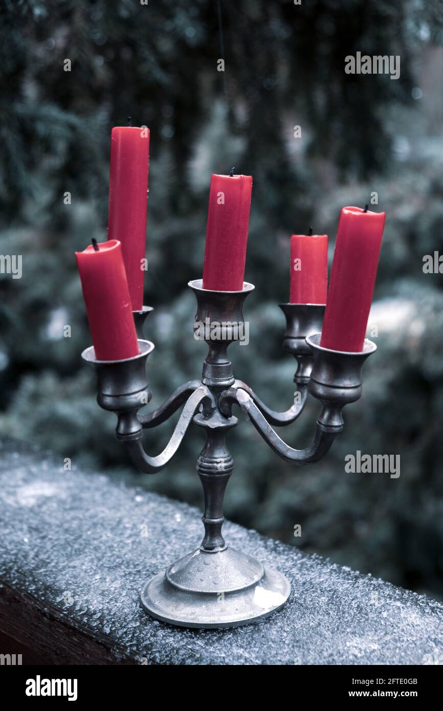chandelier en étain avec cinq bougies rouges sur la glace à l'extérieur en hiver Banque D'Images