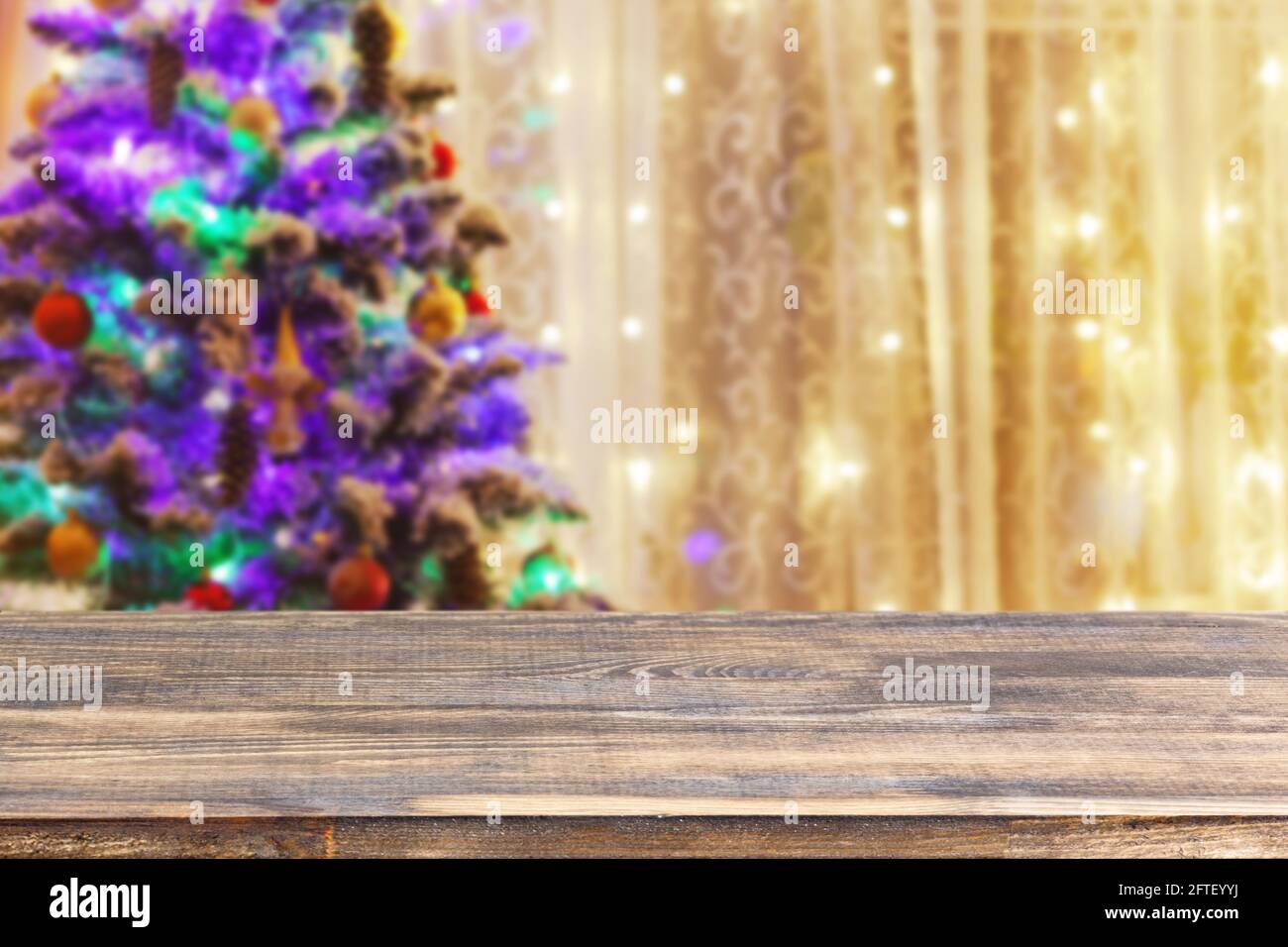 dessus de table en bois sur un arbre de noël flou avec arrière-plan guirlande Banque D'Images