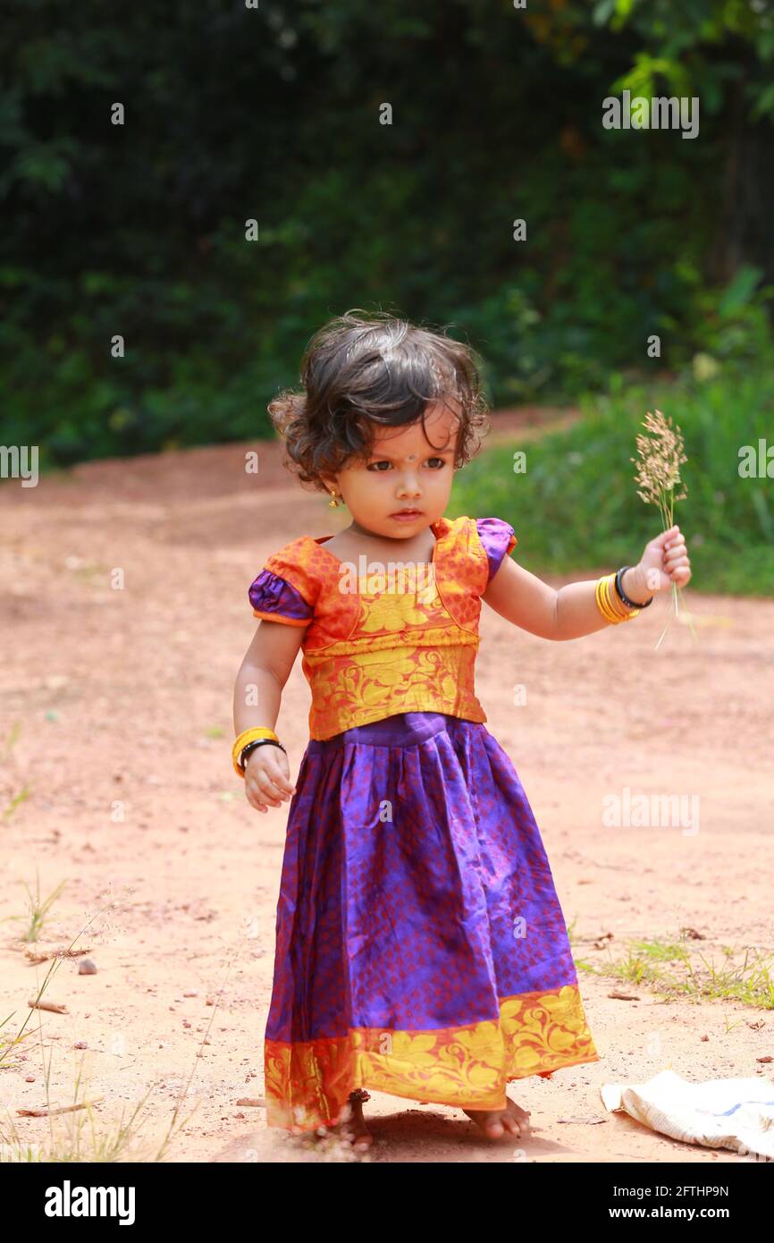 Petite fille indienne du Sud portant belle robe traditionnelle jupe longue  et un chemisier, montrant différentes expressions, un fond de verdure Photo  Stock - Alamy