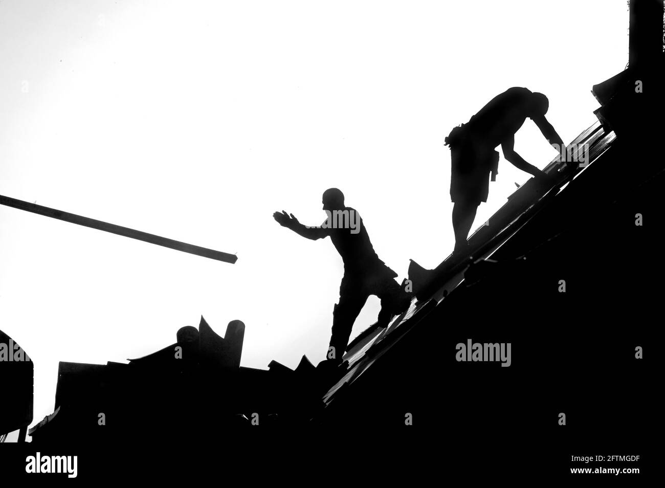 Silhouettes de deux couvreurs travaillant sur le toit d'une maison. Photo Janerik Henriksson / TT code 10010 Banque D'Images