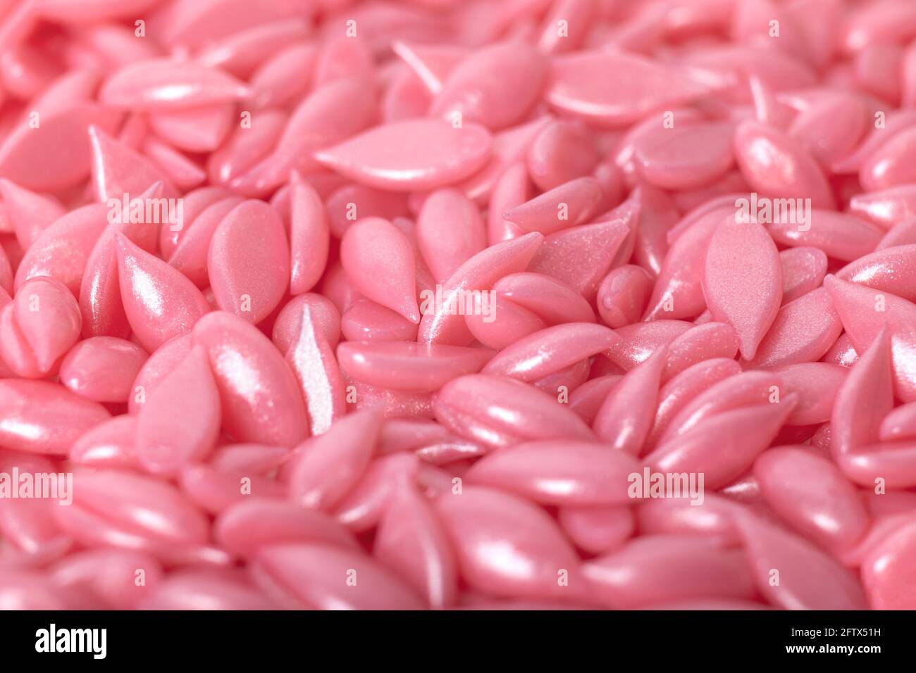 Granules de cire à film chaud, à mise au point sélective et partiellement flous pour une macrophotographie de gros plan épilatoire. Concept pour la publicité et les articles sur les cheveux de corps r Banque D'Images