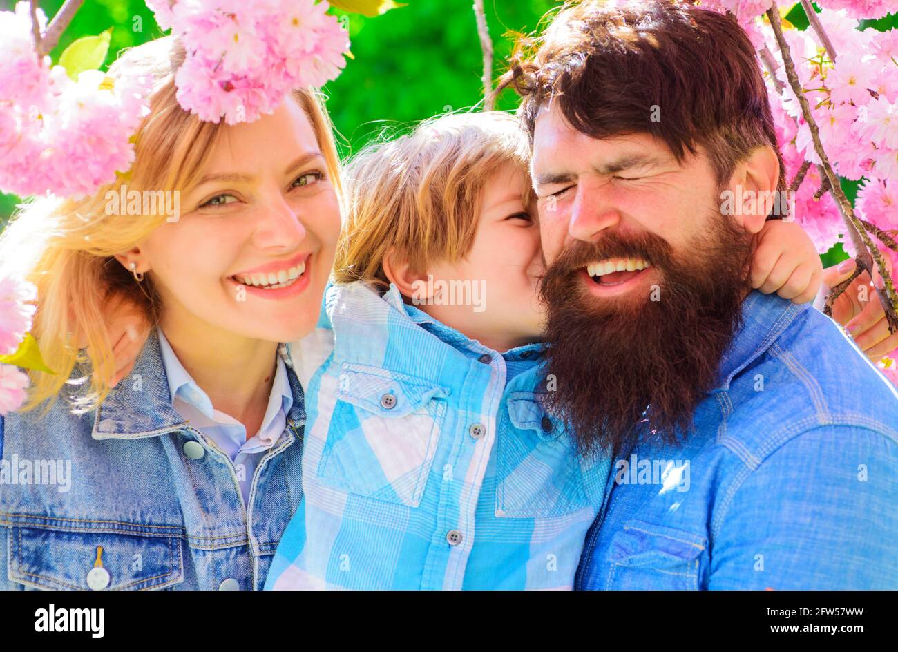 Mère, père et petit fils ensemble dans le parc de sakura en fleurs. Promenade touristique en famille dans le jardin de printemps. Banque D'Images