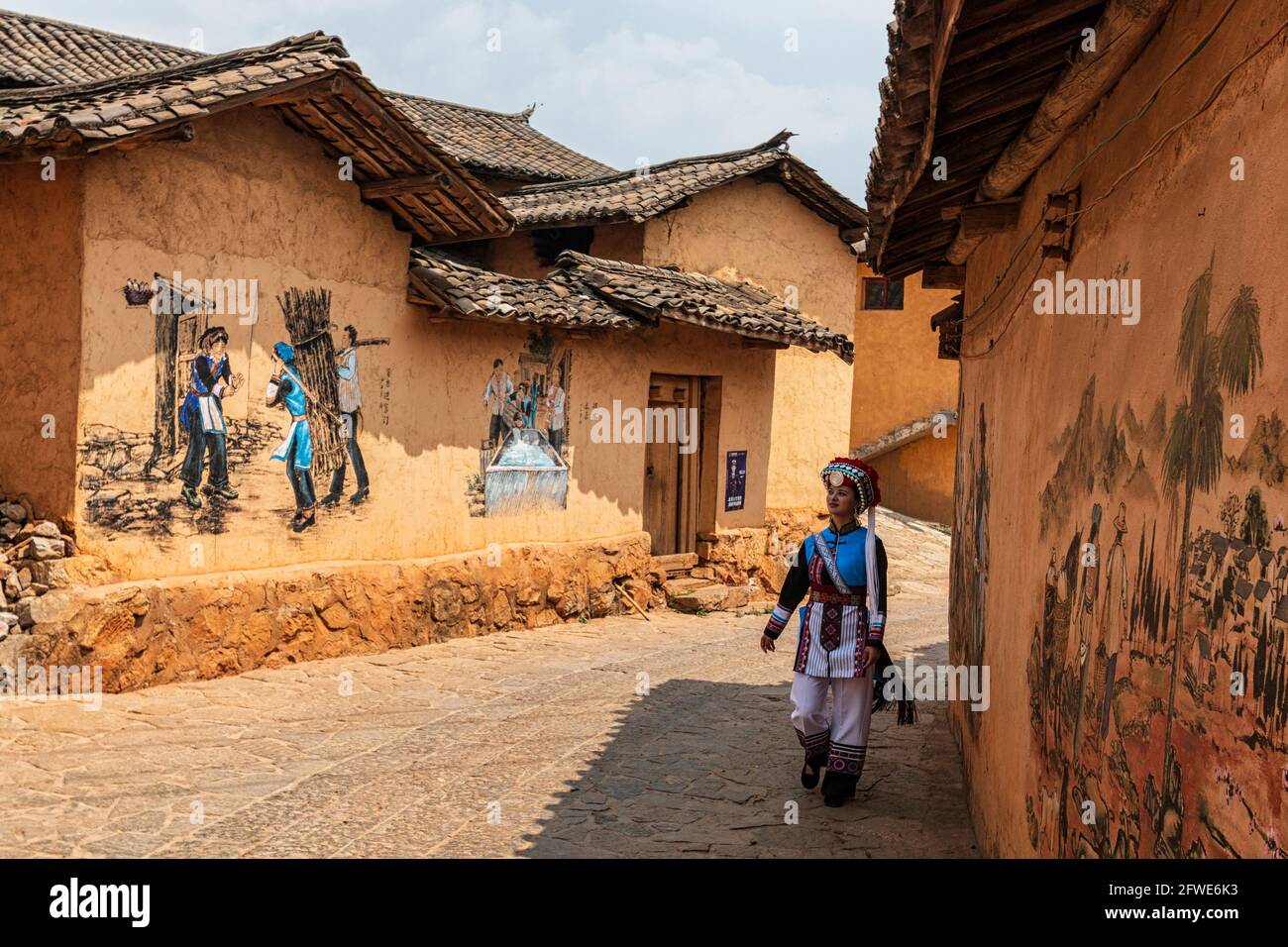 25 mars 2021 - Mile, Chine: Womand vêtu d'une tenue traditionnelle de la minorité Keyi marchant dans un village isolé Banque D'Images