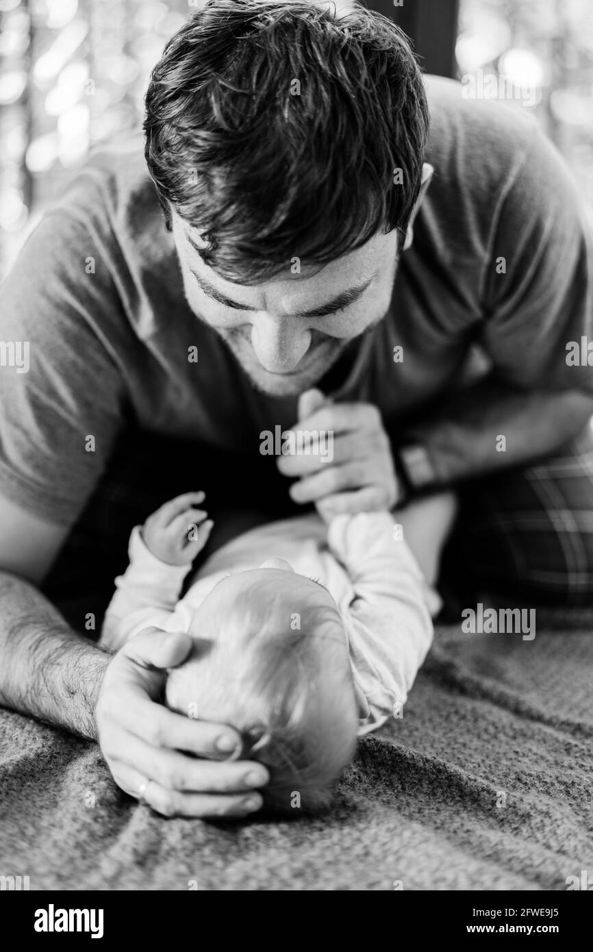 Papa A Mis Une Main Sur La Tete Du Bebe Et L Autre Tient Sa Main Bebe Et Papa Reposent Sur Le Tapis Par Terre Photo En Noir Et Blanc Photo Stock Papa A Mis Une Main Sur La Tete Du Bebe Et L Autre Tient Sa Main Bebe Et Papa Reposent Sur Le Tapis Par Terre Photo En Noir Et Blanc Photo Stock