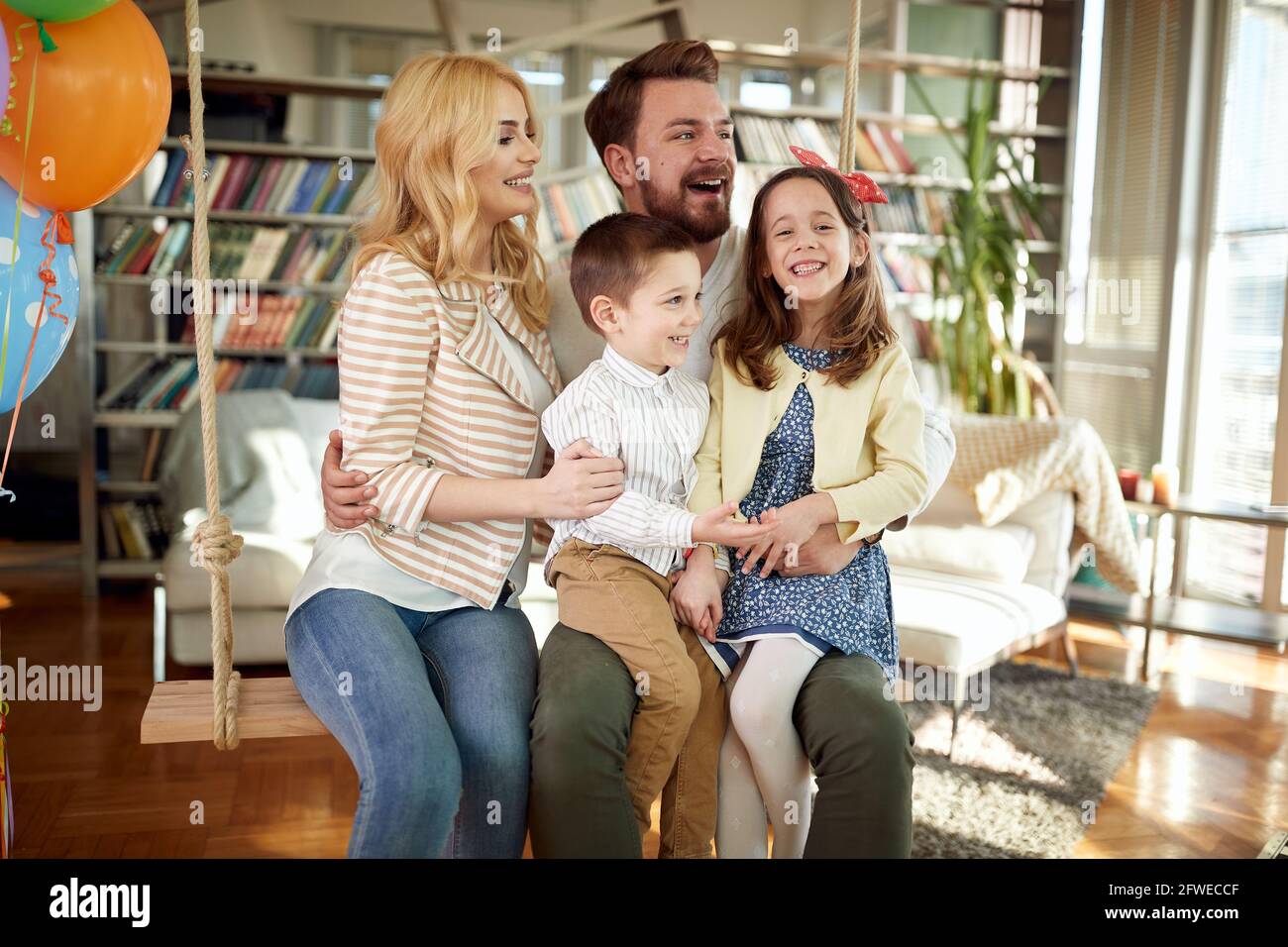 Une famille gaie qui s'amuse tout en posant pour une photo dans une atmosphère détendue à la maison ensemble. Famille, loisirs, ensemble Banque D'Images