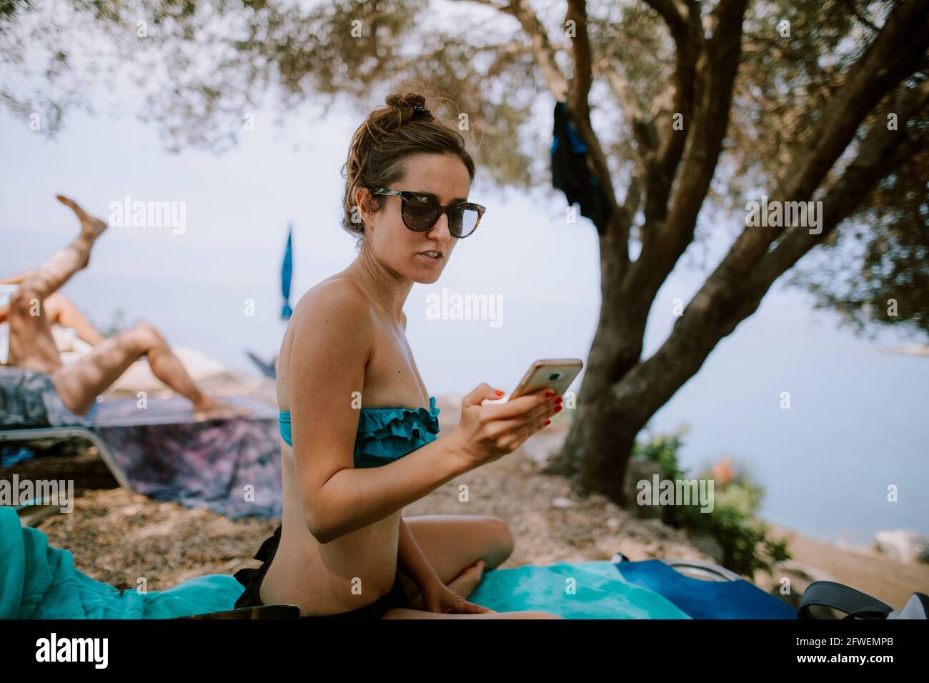 Femme utilisant un smartphone à la plage Banque D'Images