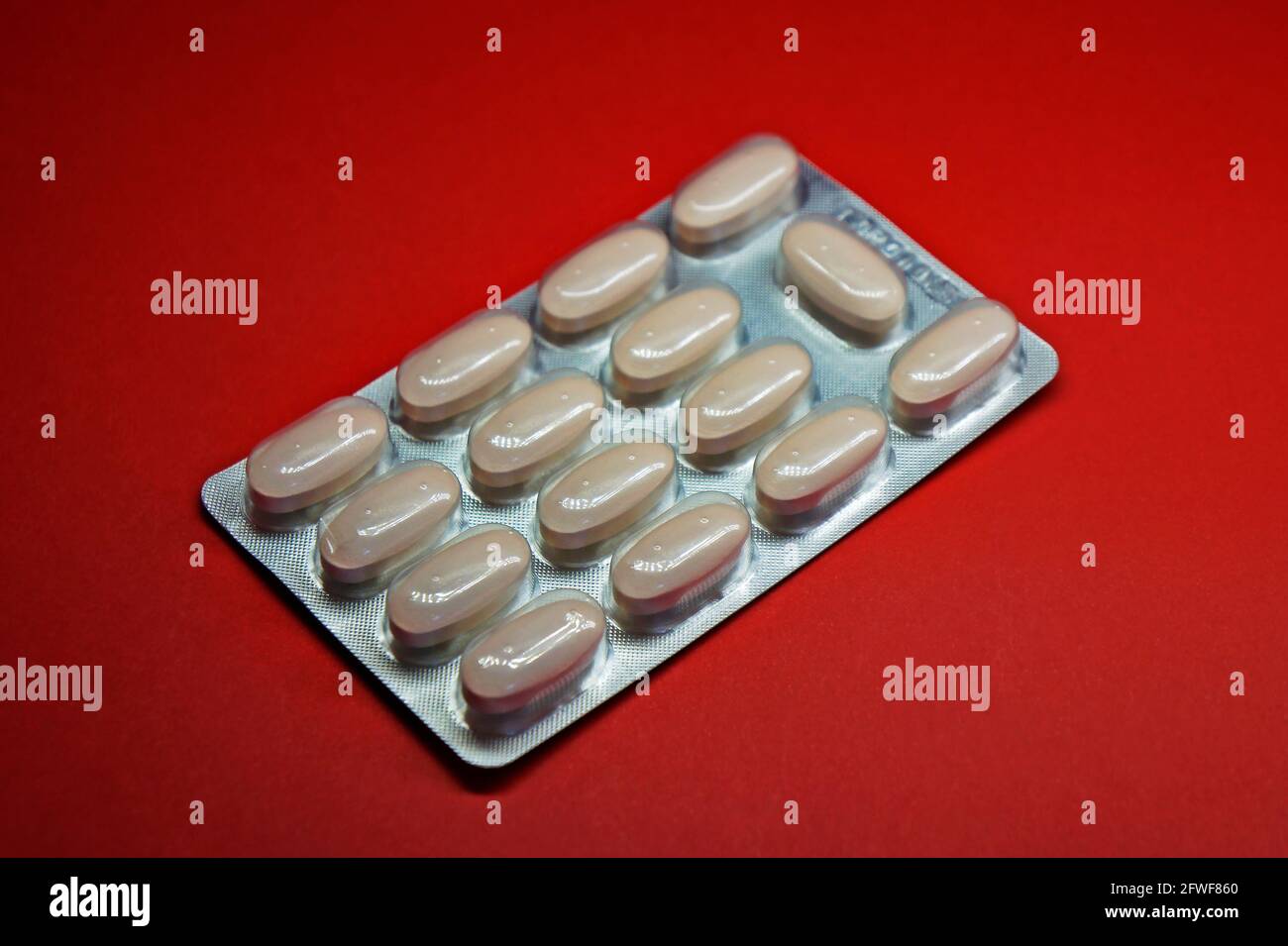 Blister de pilules sur fond rouge Banque D'Images