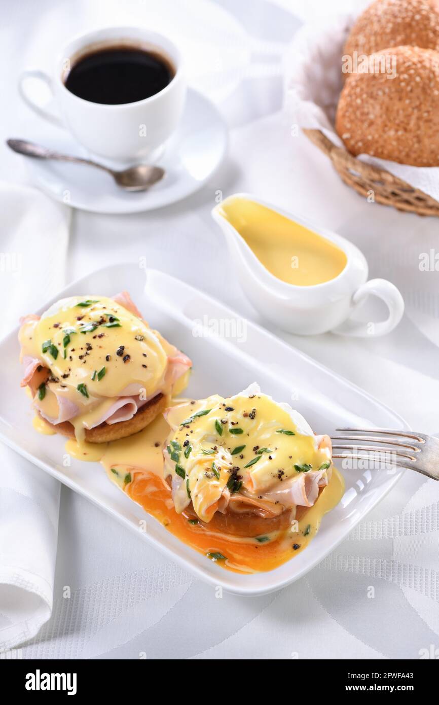 Œufs Benedict - pain anglais frit, jambon, œufs pochés et délicieuse sauce au beurre hollandaise Banque D'Images