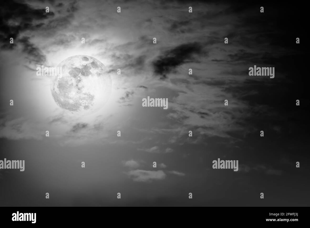 Arrière-plan du ciel nocturne avec nuage et pleine lune avec brillant. Beauté naturelle la nuit avec la lune derrière le nuage dans le style noir et blanc. Effigie vintage Banque D'Images