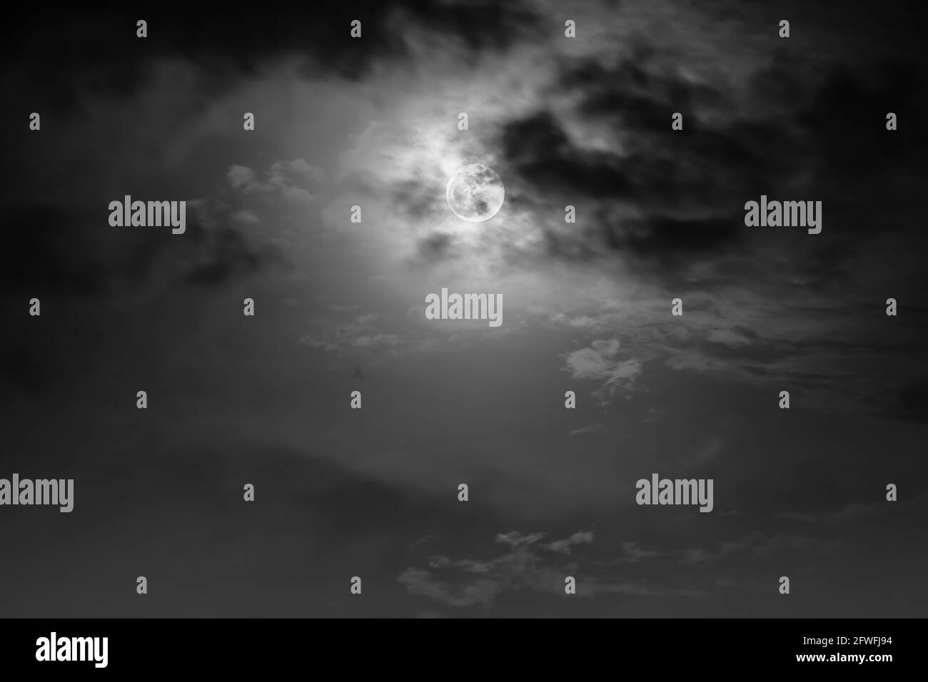 Arrière-plan du ciel nocturne avec nuage et pleine lune avec brillant. Beauté naturelle la nuit avec la lune derrière le nuage dans le style noir et blanc. Effigie vintage Banque D'Images