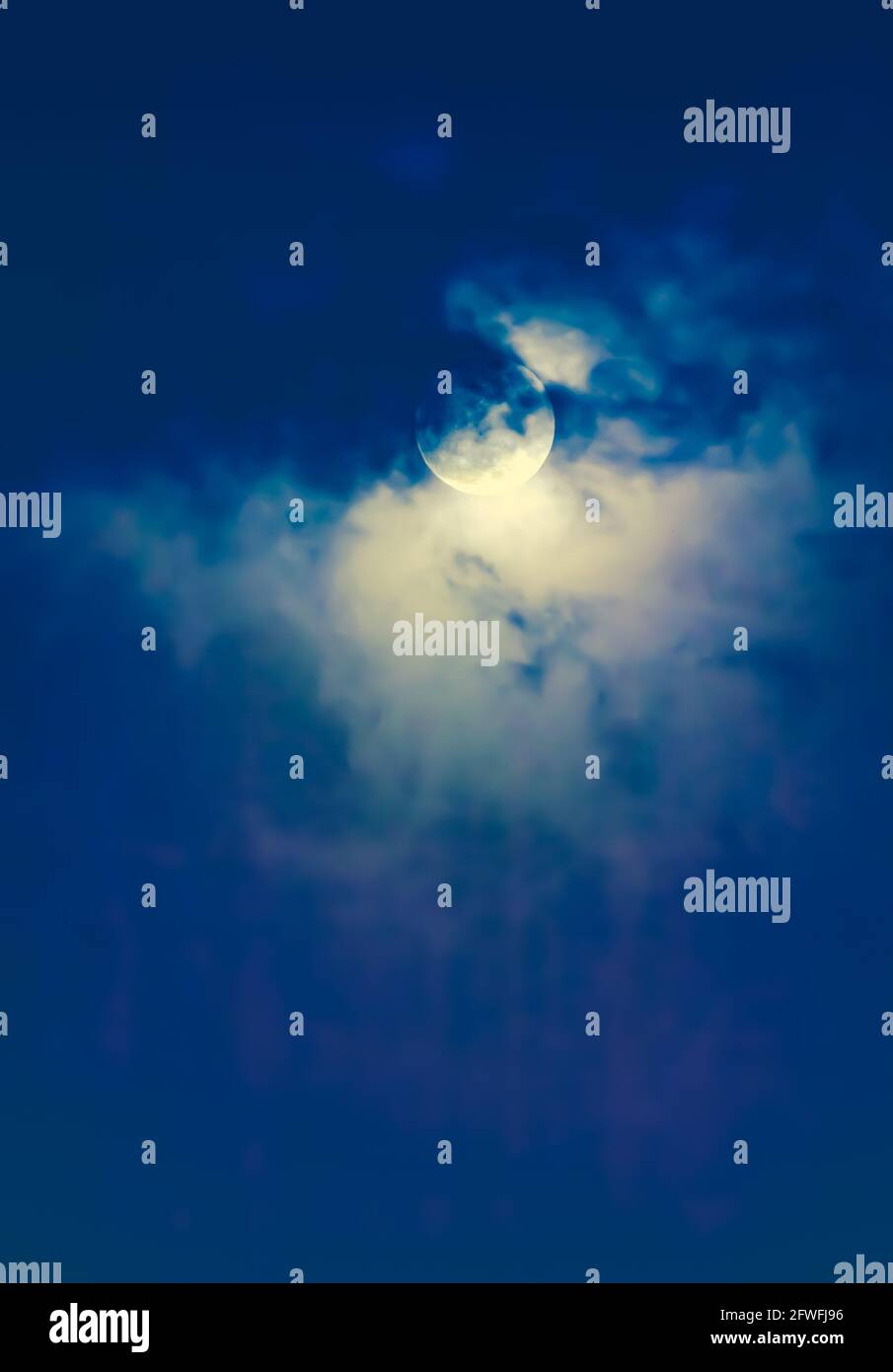 Arrière-plan du ciel nocturne avec nuage et pleine lune avec brillant. Beauté naturelle la nuit avec une magnifique lune derrière le nuage. Processus croisé et vintage Banque D'Images