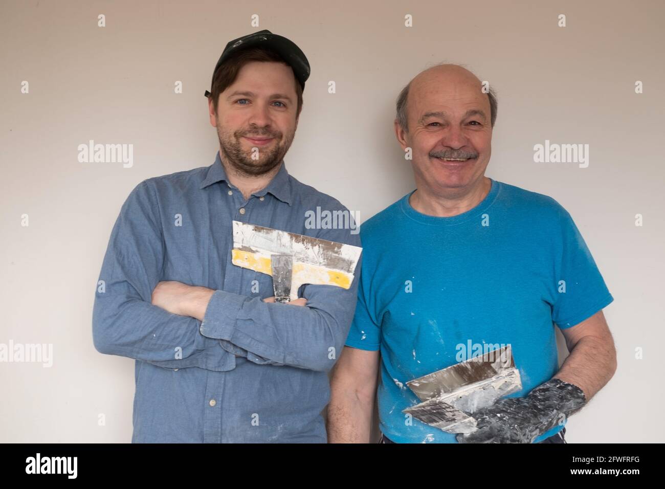 Hommes de main mûrs avec couteau à mastiquer souriant regardant l'appareil photo Banque D'Images