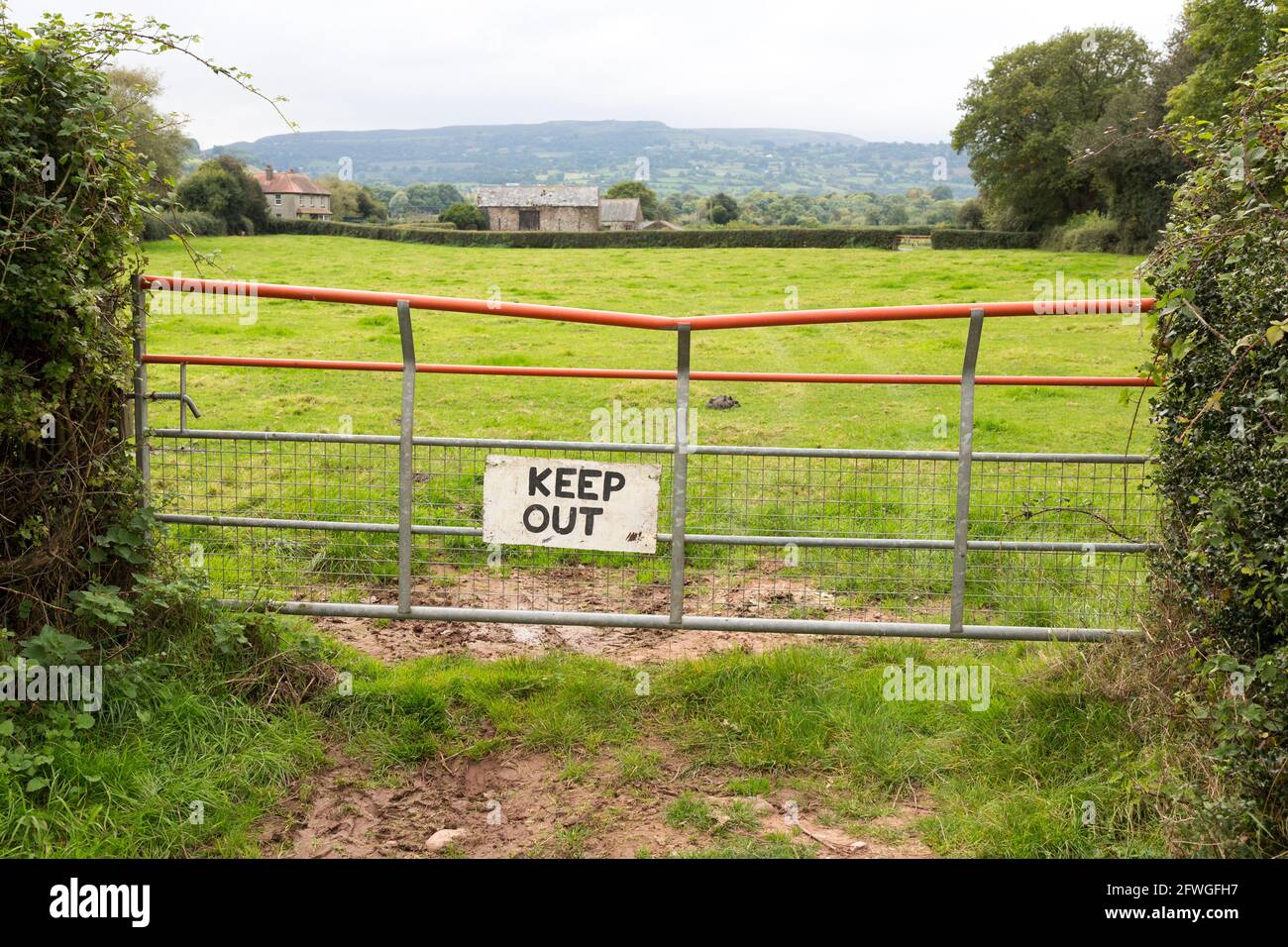 Champ avec porte et panneau de maintien, Pyscodlyn, pays de Galles, Royaume-Uni Banque D'Images