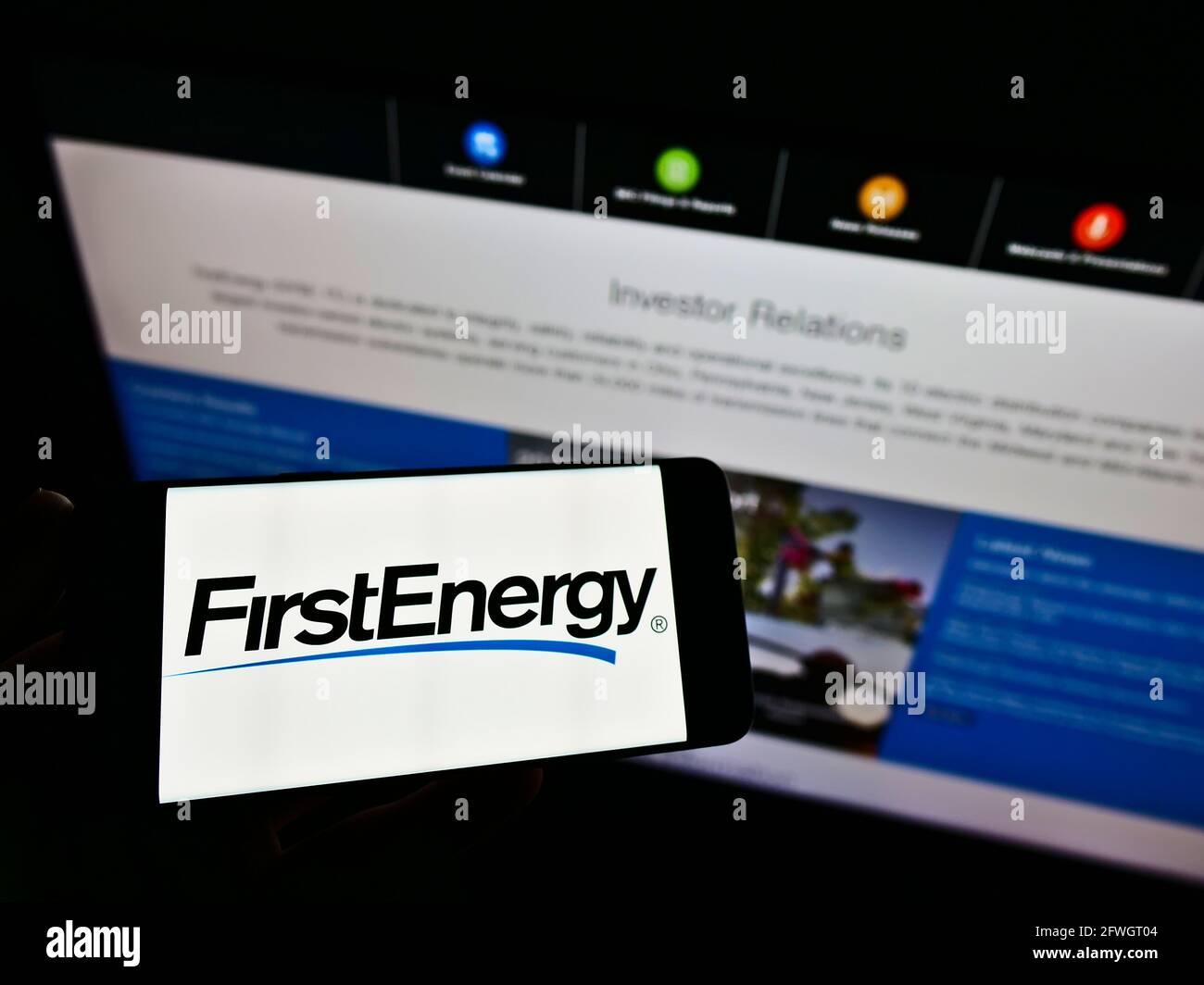 Personne tenant un smartphone avec le logo de la société américaine d'électricité FirstEnergy Corp. Sur l'écran devant le site Web. Mise au point sur l'affichage du téléphone. Banque D'Images