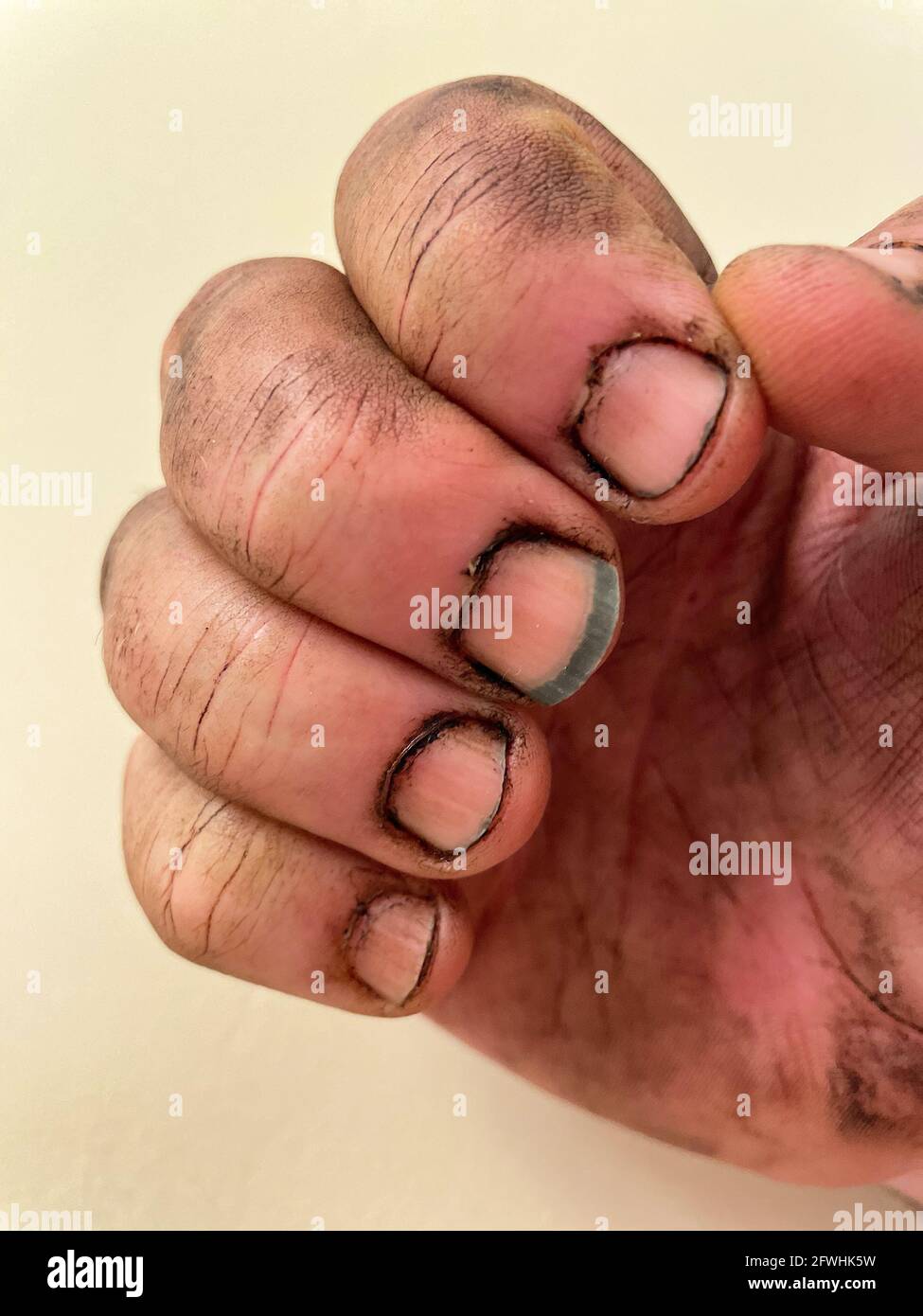 Gros plan des doigts sales d'un homme après avoir travaillé sur un équipement sale avec de la saleté sous ses ongles. Banque D'Images