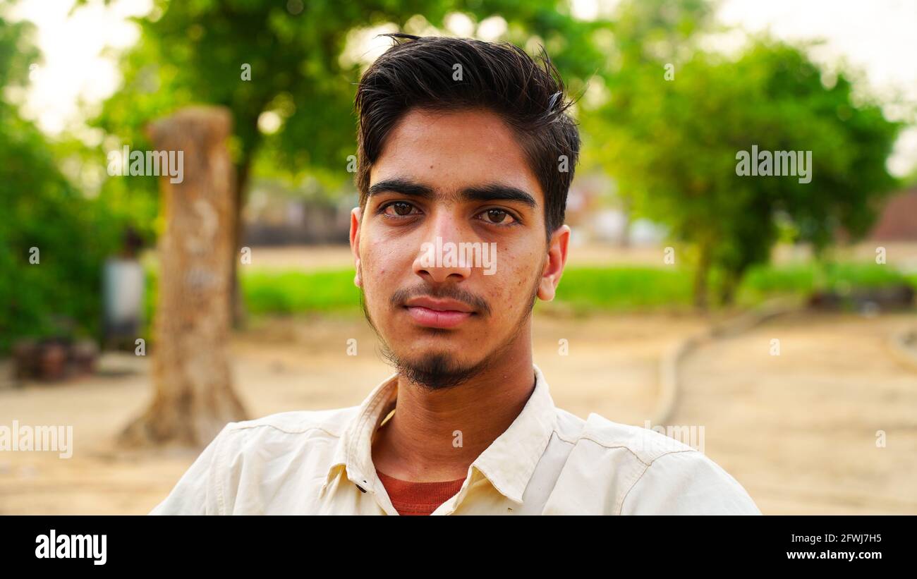 Gros plan sur le visage d'un jeune garçon indien à la mode sur fond vert. Banque D'Images