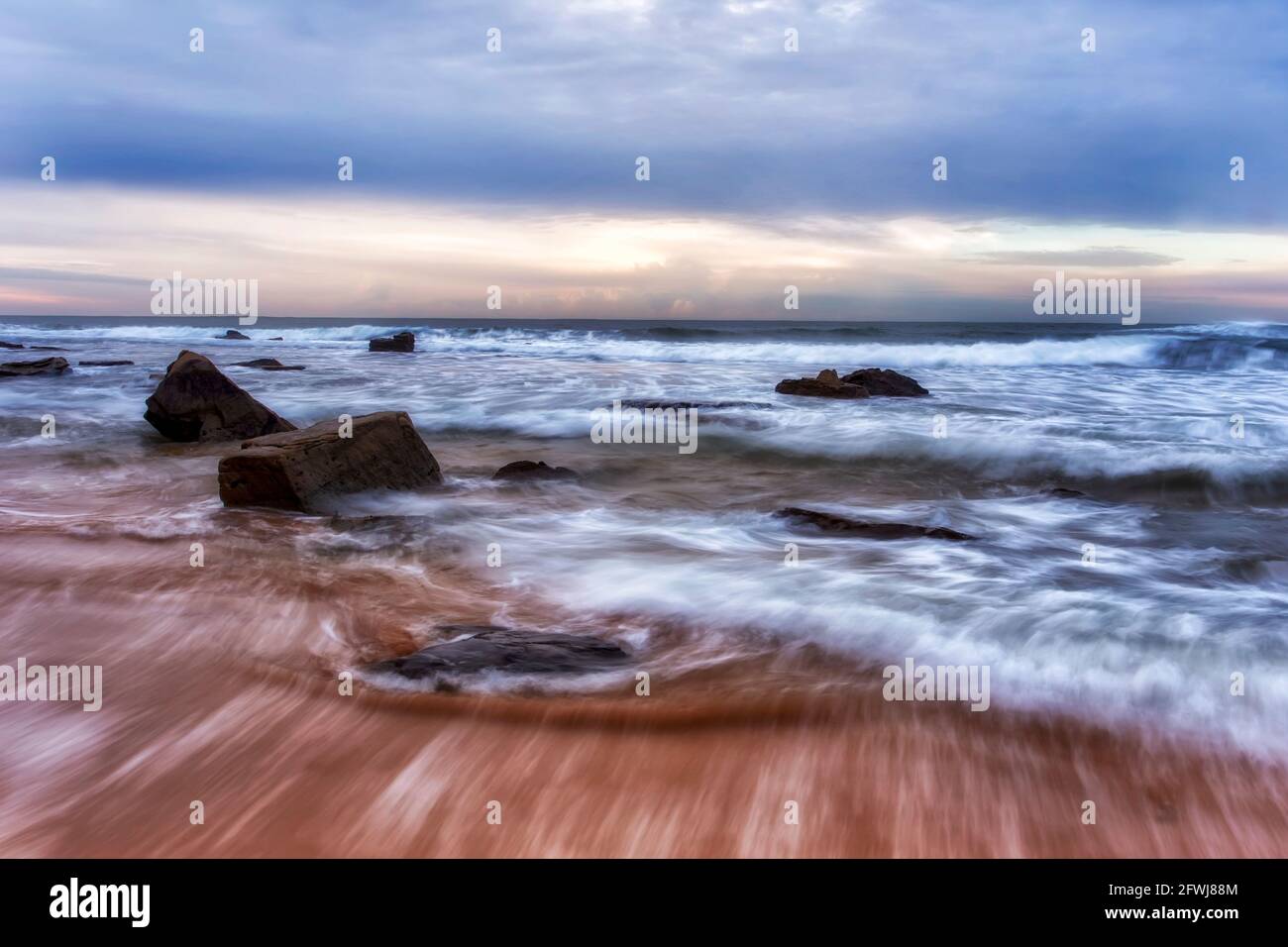 Rochers de grès érodés sur la plage de Mona Vale de Sydney plages du Nord au lever du soleil - paysage marin pittoresque. Banque D'Images