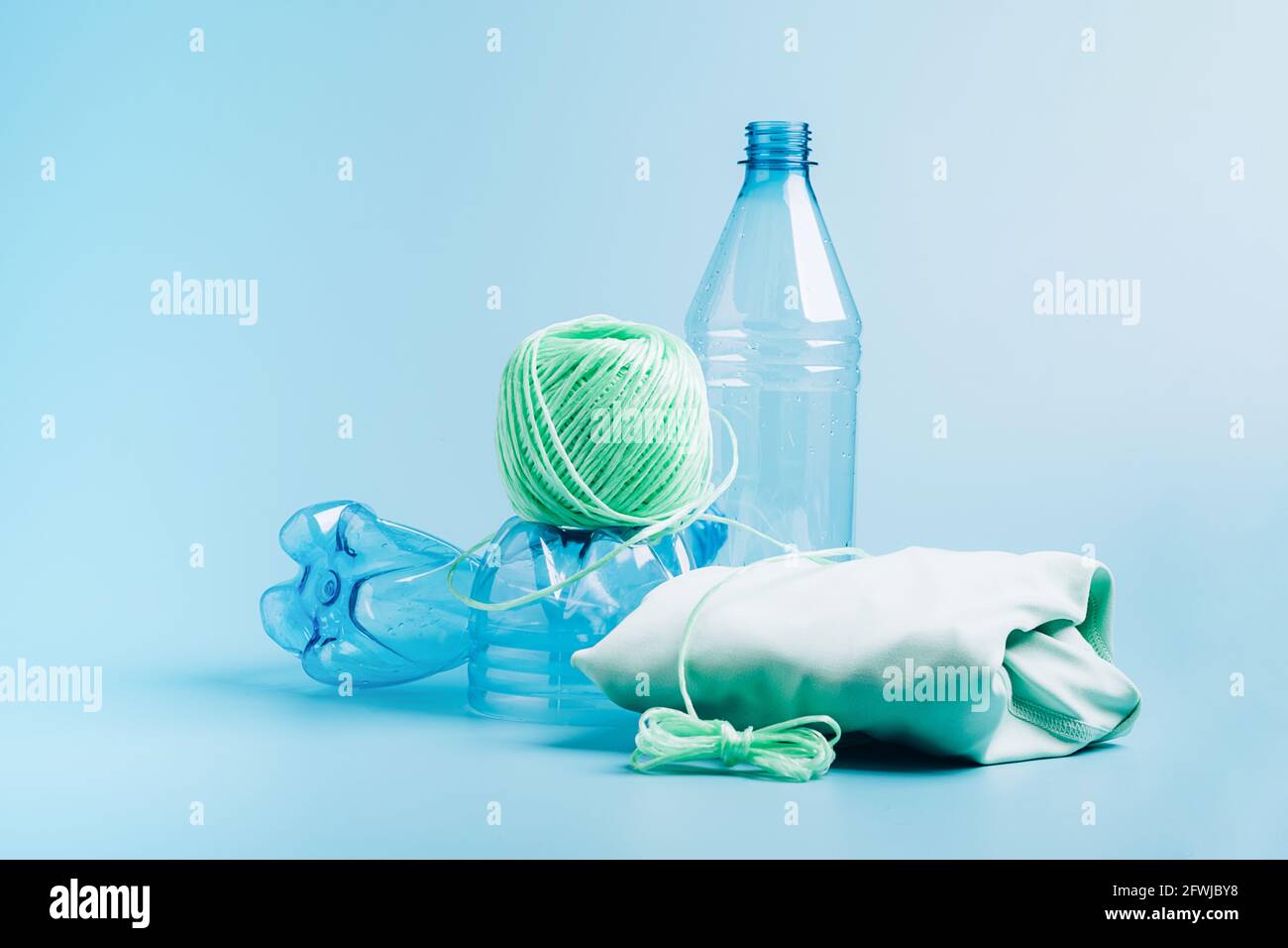 Le concept de recyclage et de réutilisation du plastique. Bouteille en  plastique vide et fibre de polyester recyclée, tissu synthétique sur fond  bleu. Environnement Photo Stock - Alamy