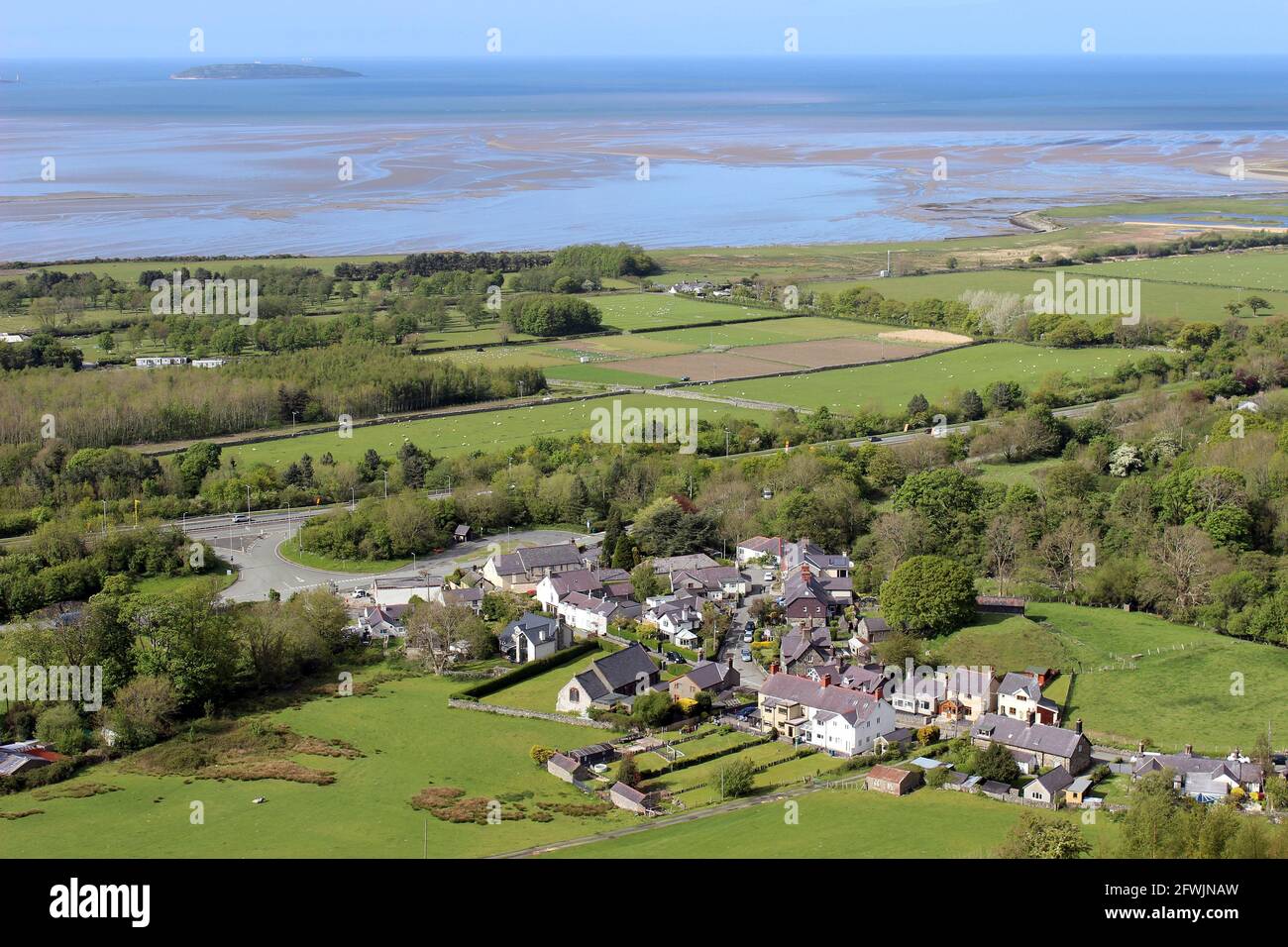 Vue depuis le chemin du nord du pays de Galles en regardant vers le bas sur le village d'Abergwyngregyn, Gwynedd, pays de Galles avec Penmon point et Puffin Island au loin Banque D'Images