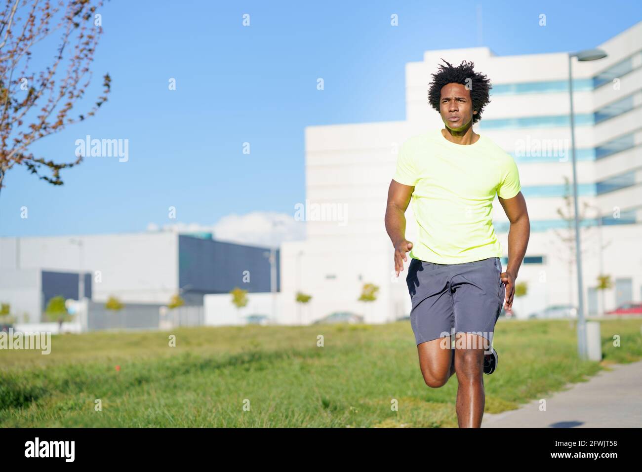 Homme sportif noir courant dans un parc urbain. Banque D'Images
